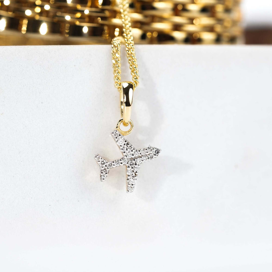 A gleaming silver-and-gold watch with a dangling airplane pendant, reflecting a love for travel and timeless elegance in one accessory.