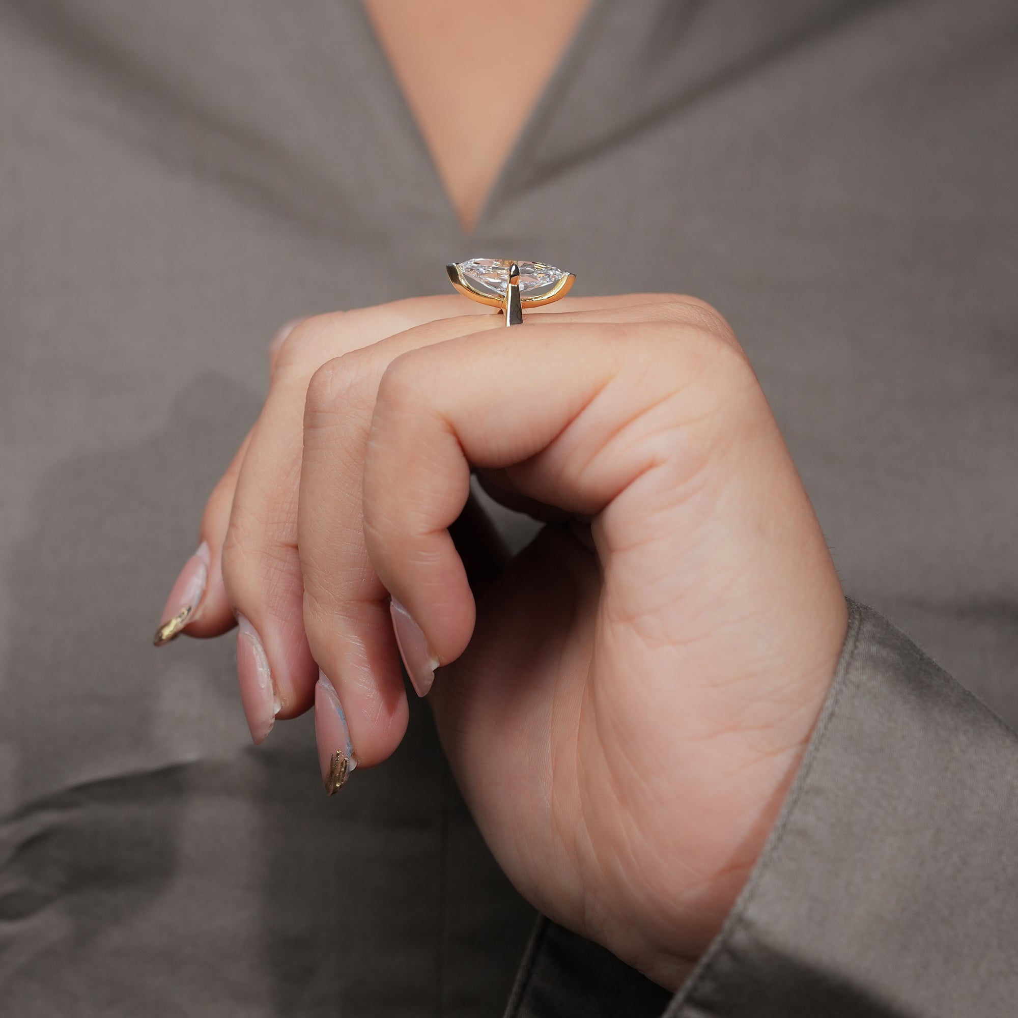 Gold ring with a marquise-cut diamond solitaire on a polished band.