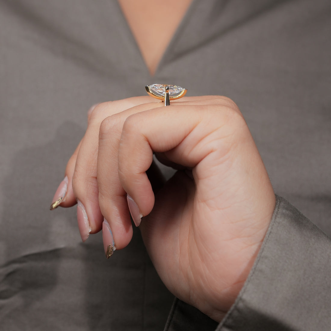 Gold ring with a marquise-cut diamond solitaire on a polished band.