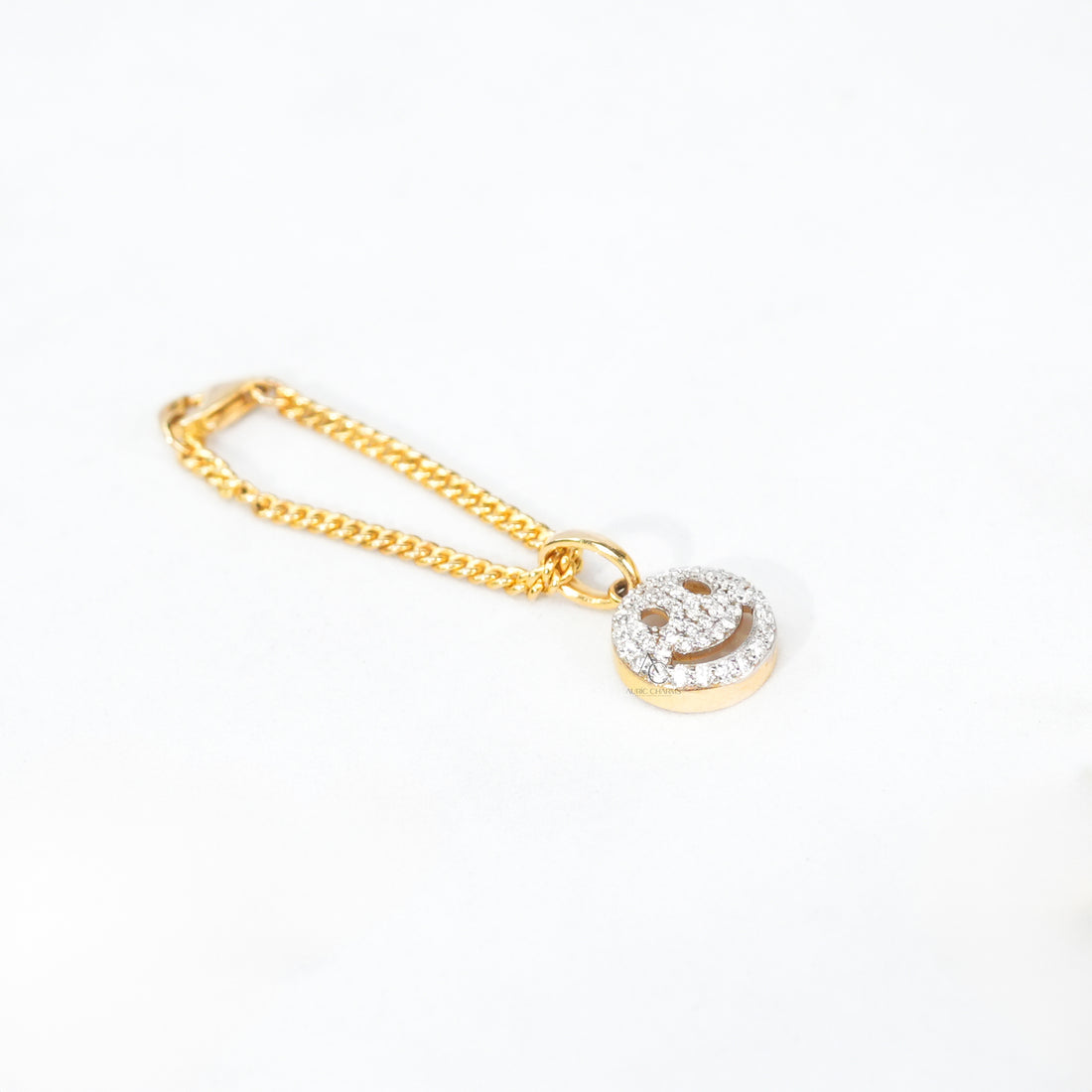 Two-tone bracelet watch with a small gold smiley charm, offering a fun and elegant finishing touch.
