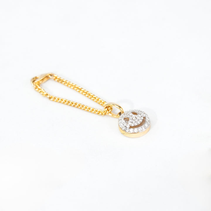 Two-tone bracelet watch with a small gold smiley charm, offering a fun and elegant finishing touch.