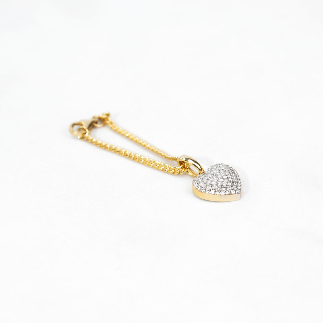 Two-tone watch with a small diamond heart charm, adding a subtle touch of sparkle and femininity.