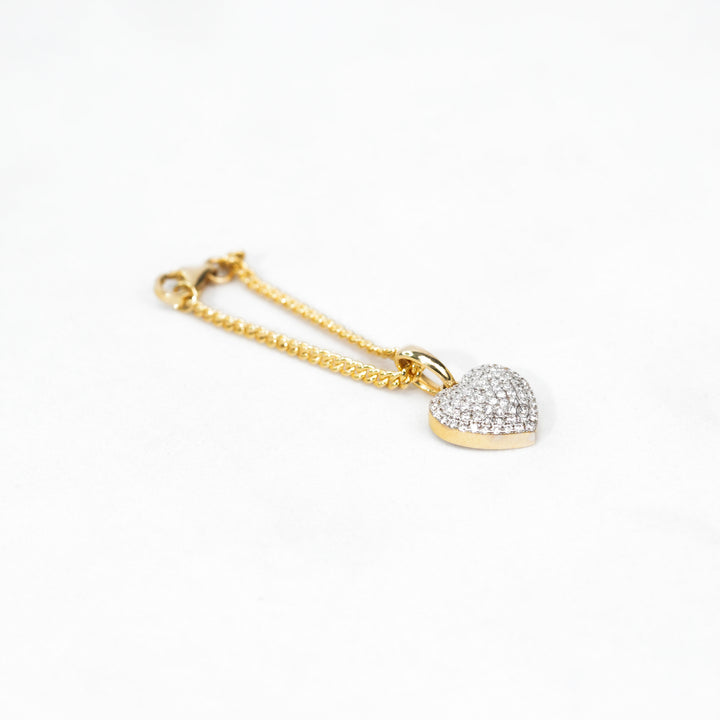 Two-tone watch with a small diamond heart charm, adding a subtle touch of sparkle and femininity.