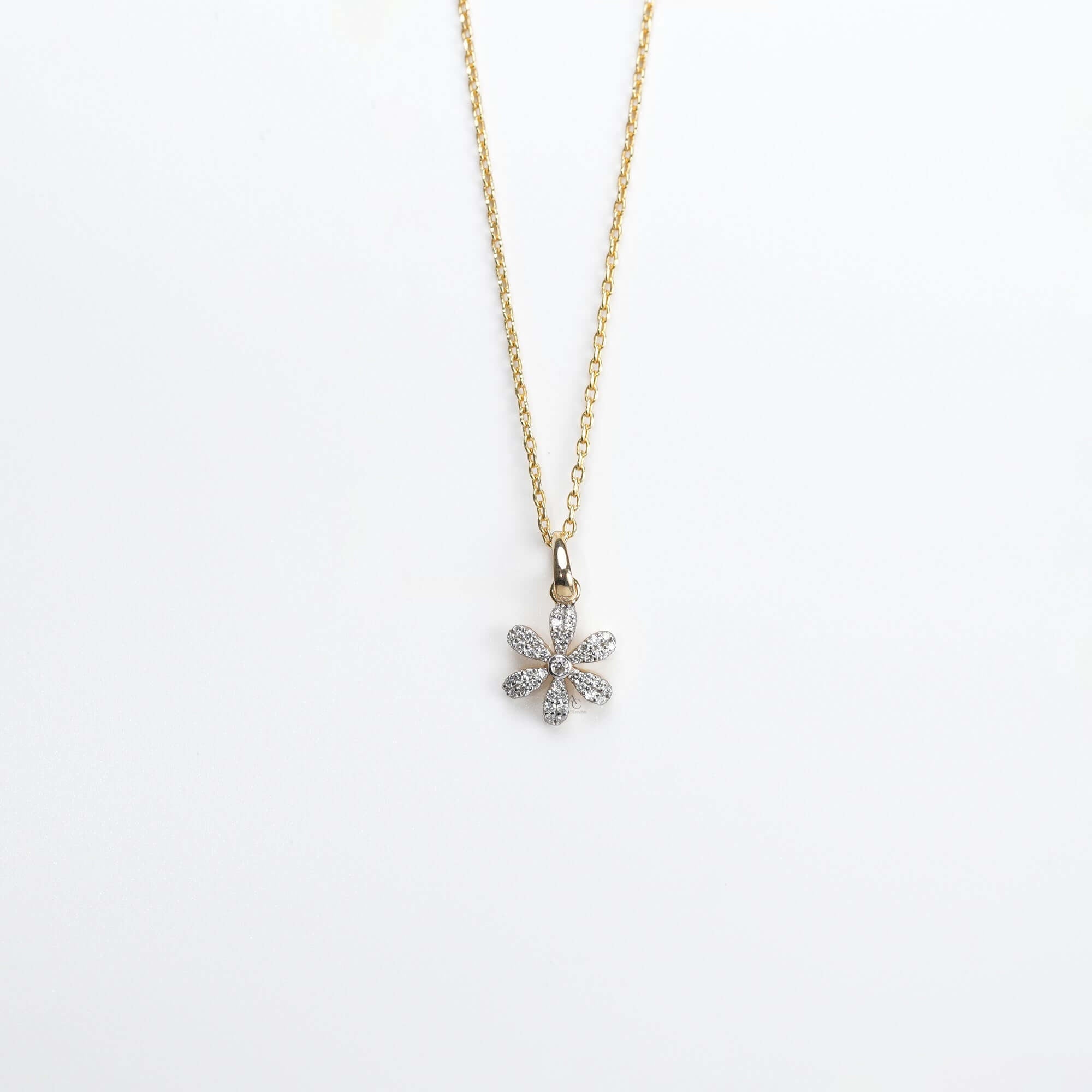 A graceful gold necklace with a diamond-studded floral pendant, symbolizing beauty, joy, and timeless elegance.
