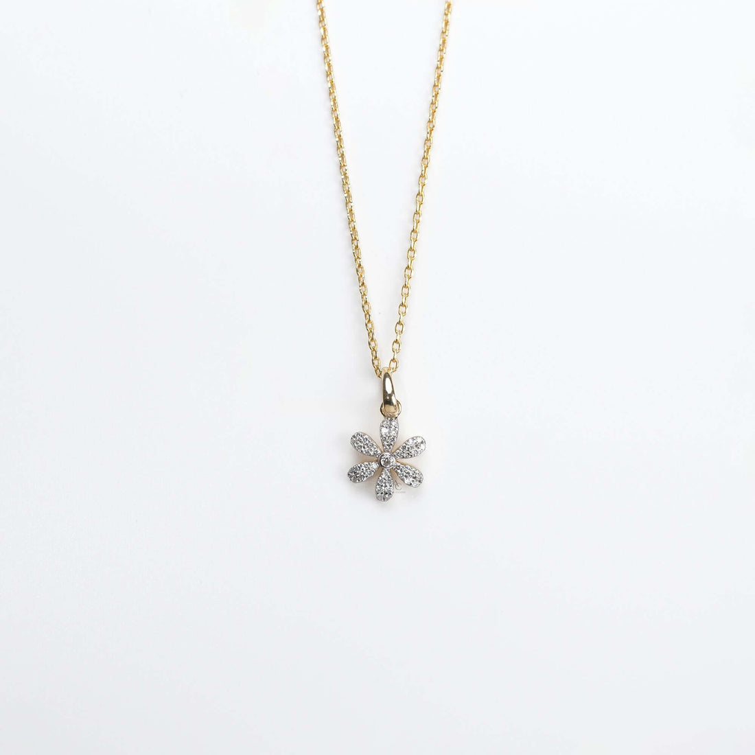 A graceful gold necklace with a diamond-studded floral pendant, symbolizing beauty, joy, and timeless elegance.