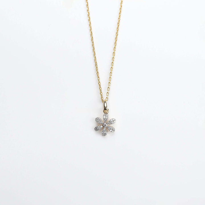 A graceful gold necklace with a diamond-studded floral pendant, symbolizing beauty, joy, and timeless elegance.