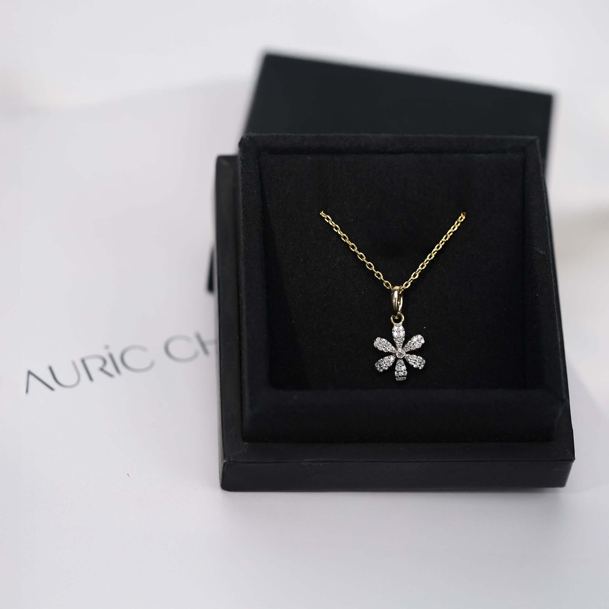 Gold floral pendant necklace with diamond petals, refined and luxurious presentation.