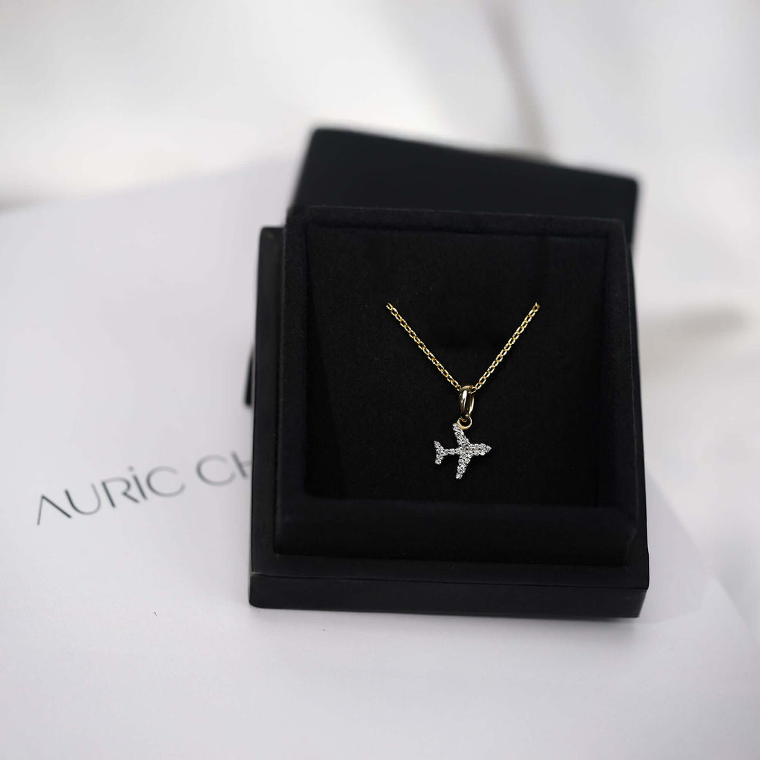 Gold airplane pendant necklace with diamond accents, a travel-inspired jewelry piece perfect for everyday wear or gifting.