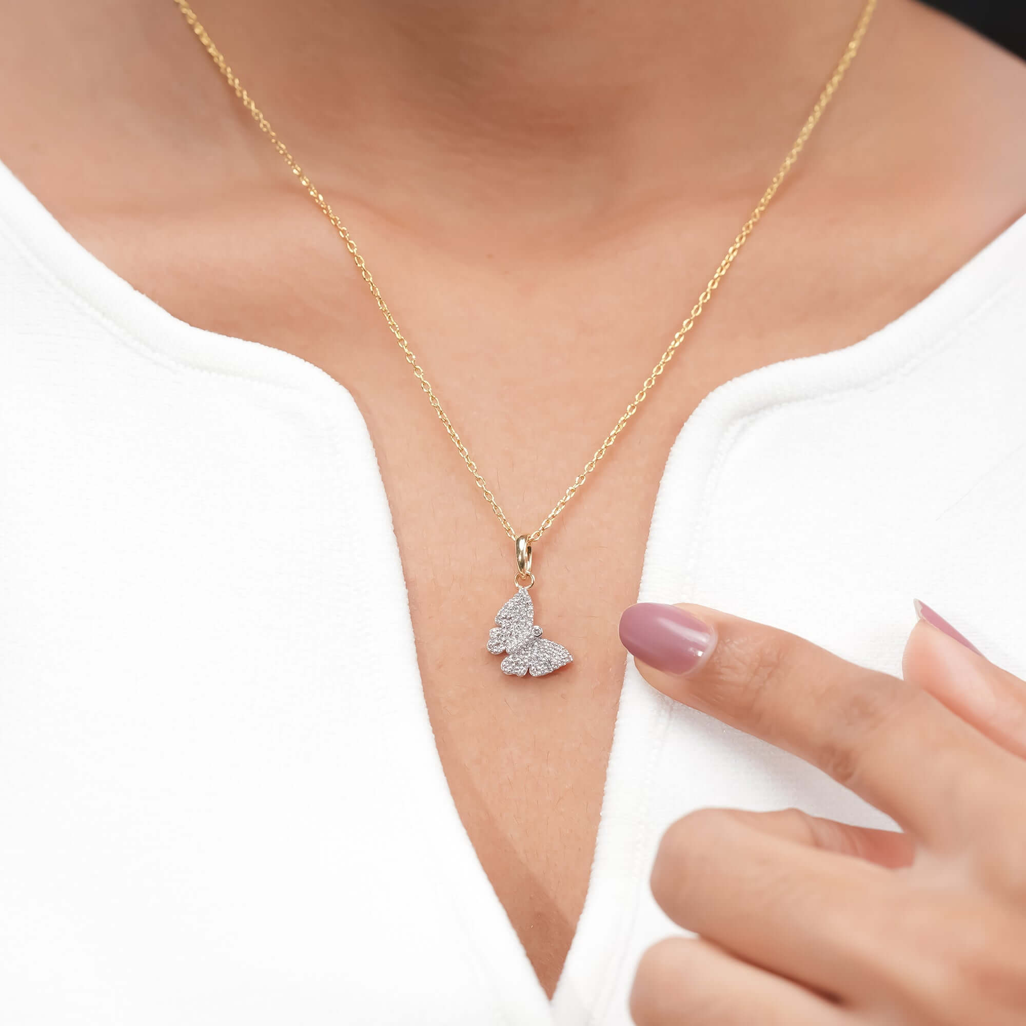 Gold chain with a diamond-encrusted butterfly pendant, elegant look.