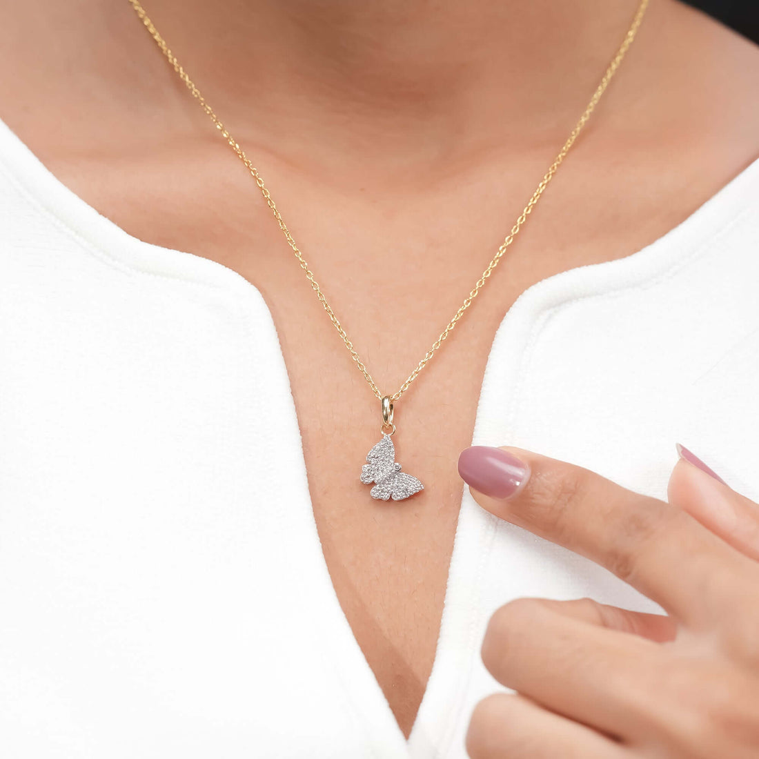 Gold chain with a diamond-encrusted butterfly pendant, elegant look.