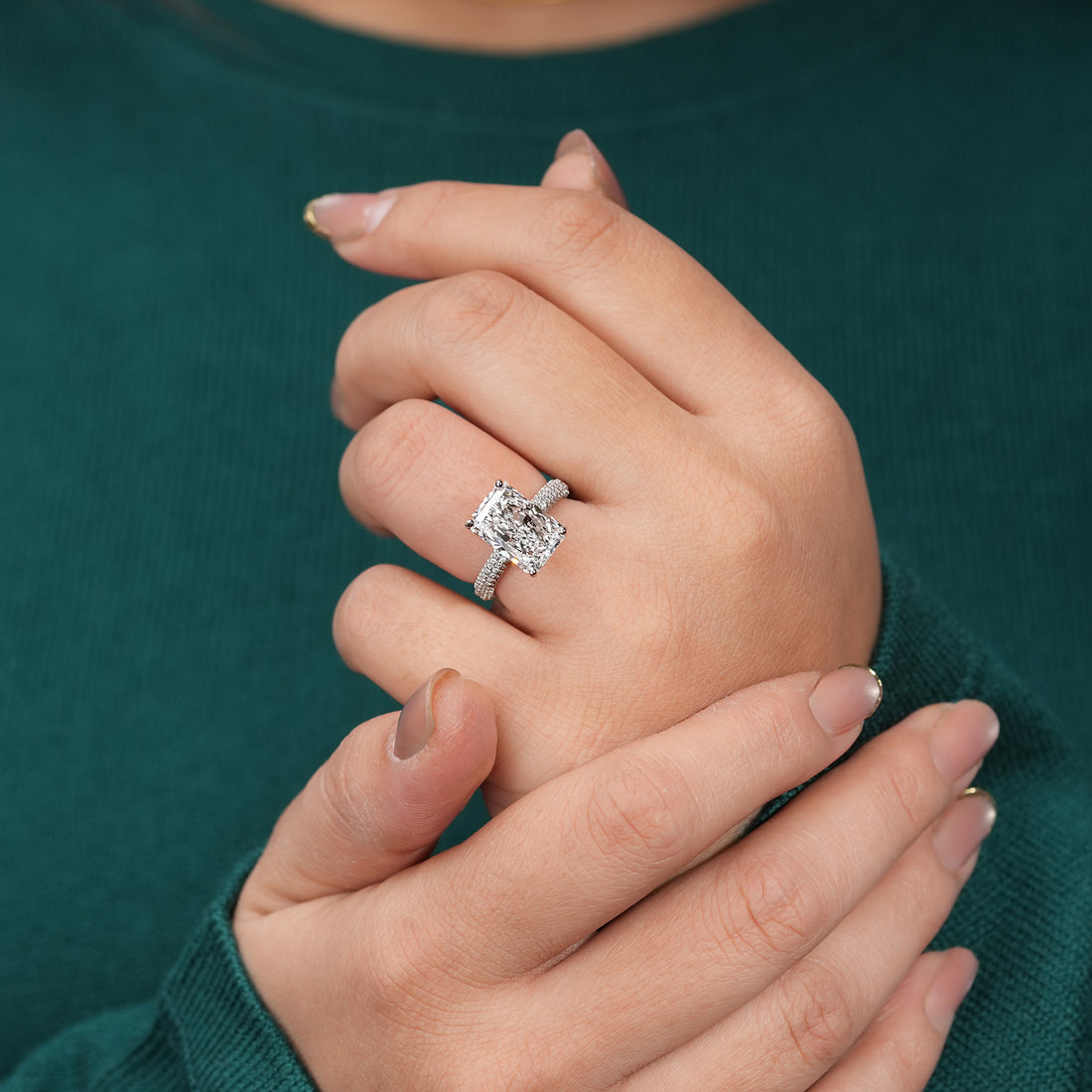 Radiant-cut diamond engagement ring in white gold or platinum with a pavé diamond band, featuring a large rectangular center stone and brilliant side detailing.