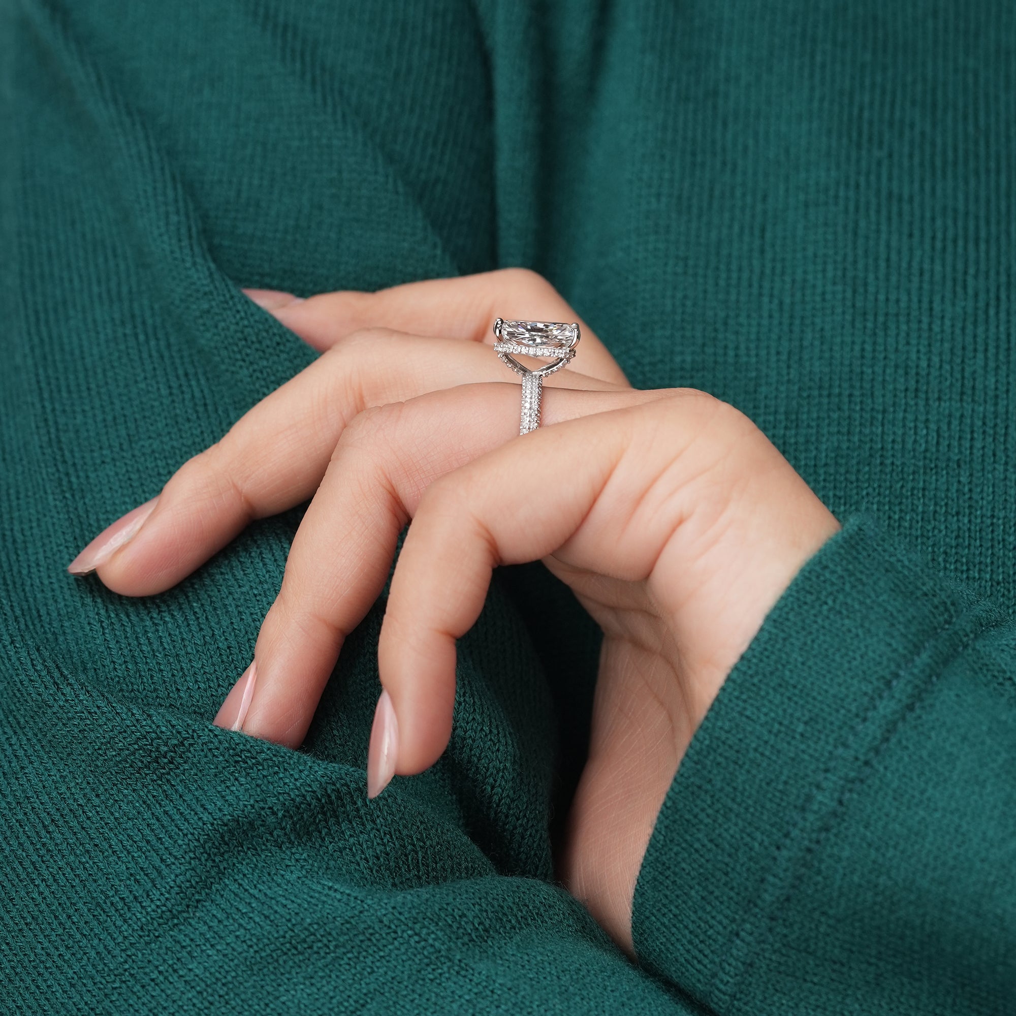 A stunning radiant-cut diamond sits atop a pavé diamond band, its facets catching the light to create a dazzling display of fire and clarity.