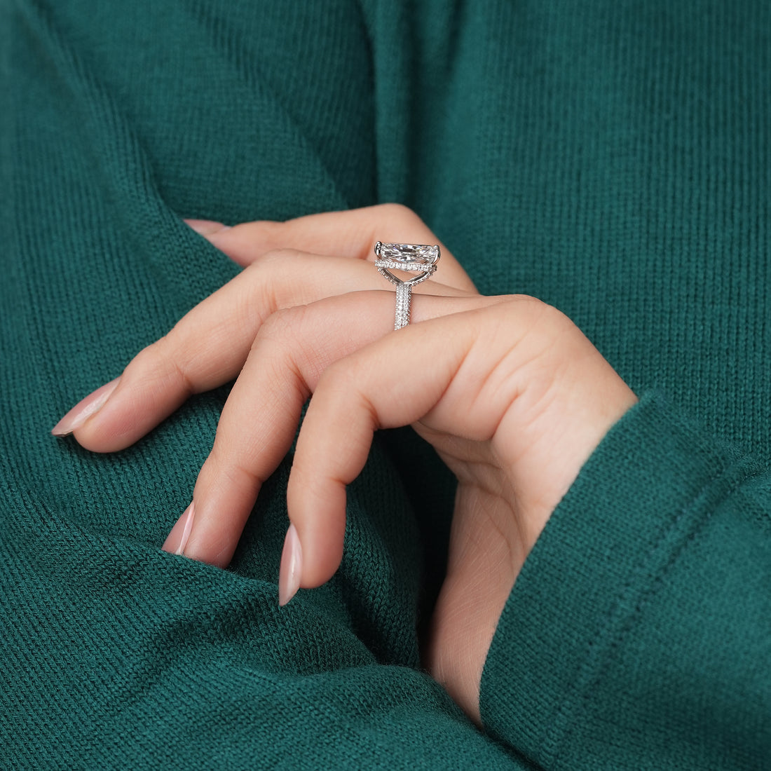 A stunning radiant-cut diamond sits atop a pavé diamond band, its facets catching the light to create a dazzling display of fire and clarity.