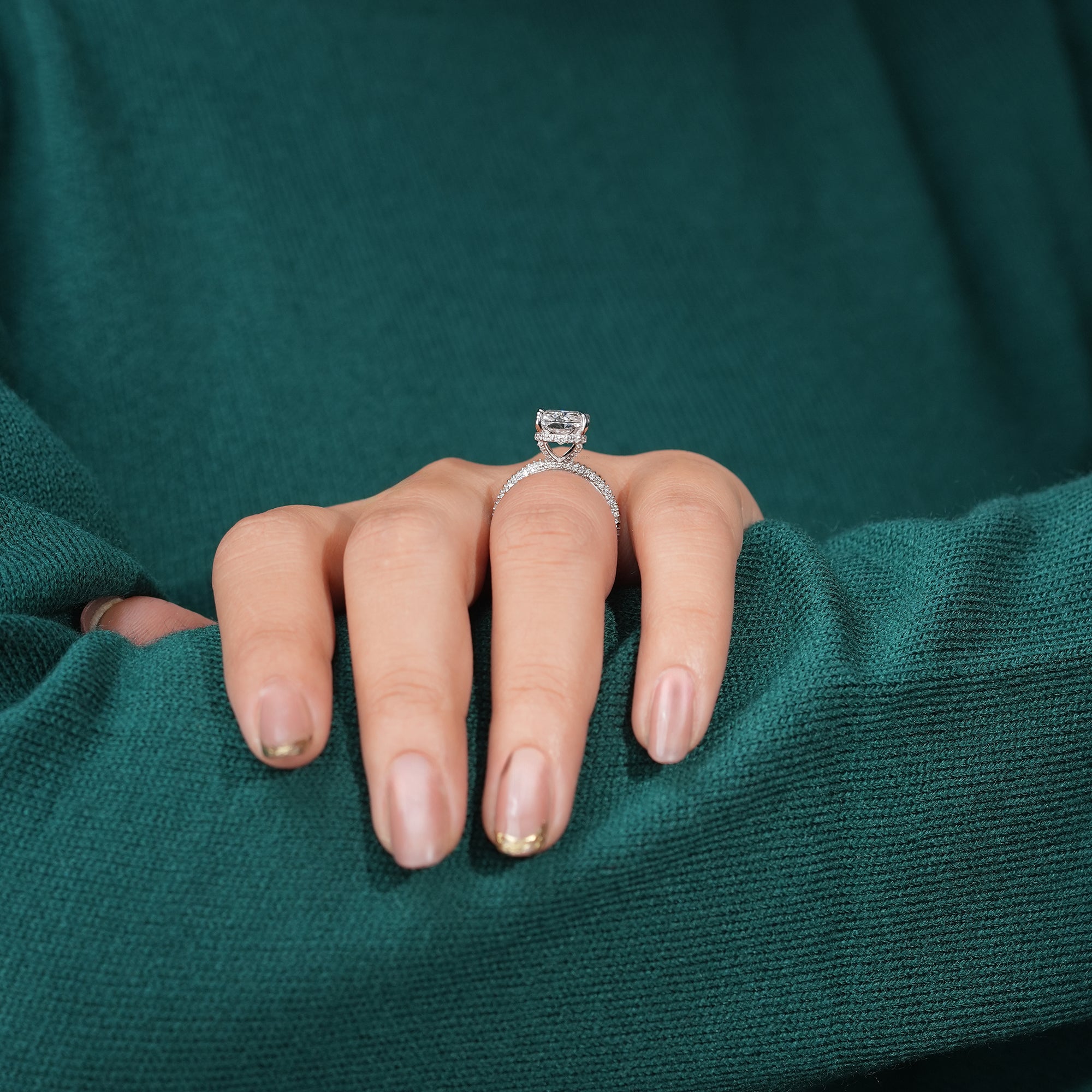 Platinum ring with a radiant-cut diamond center and a pavé diamond band.