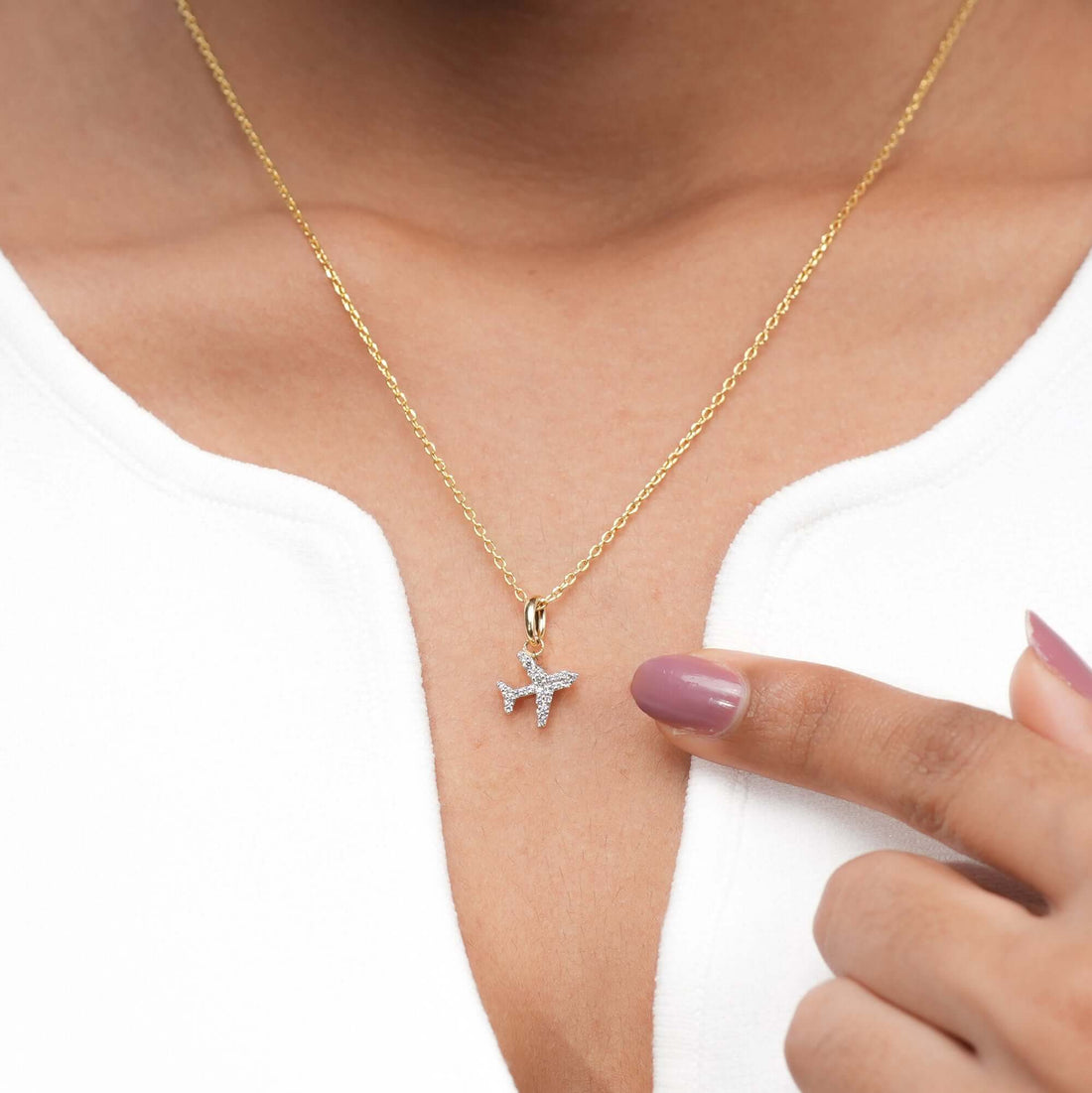 An elegant gold necklace featuring a pavé diamond airplane charm, designed for those who embrace sophistication and a love for travel.