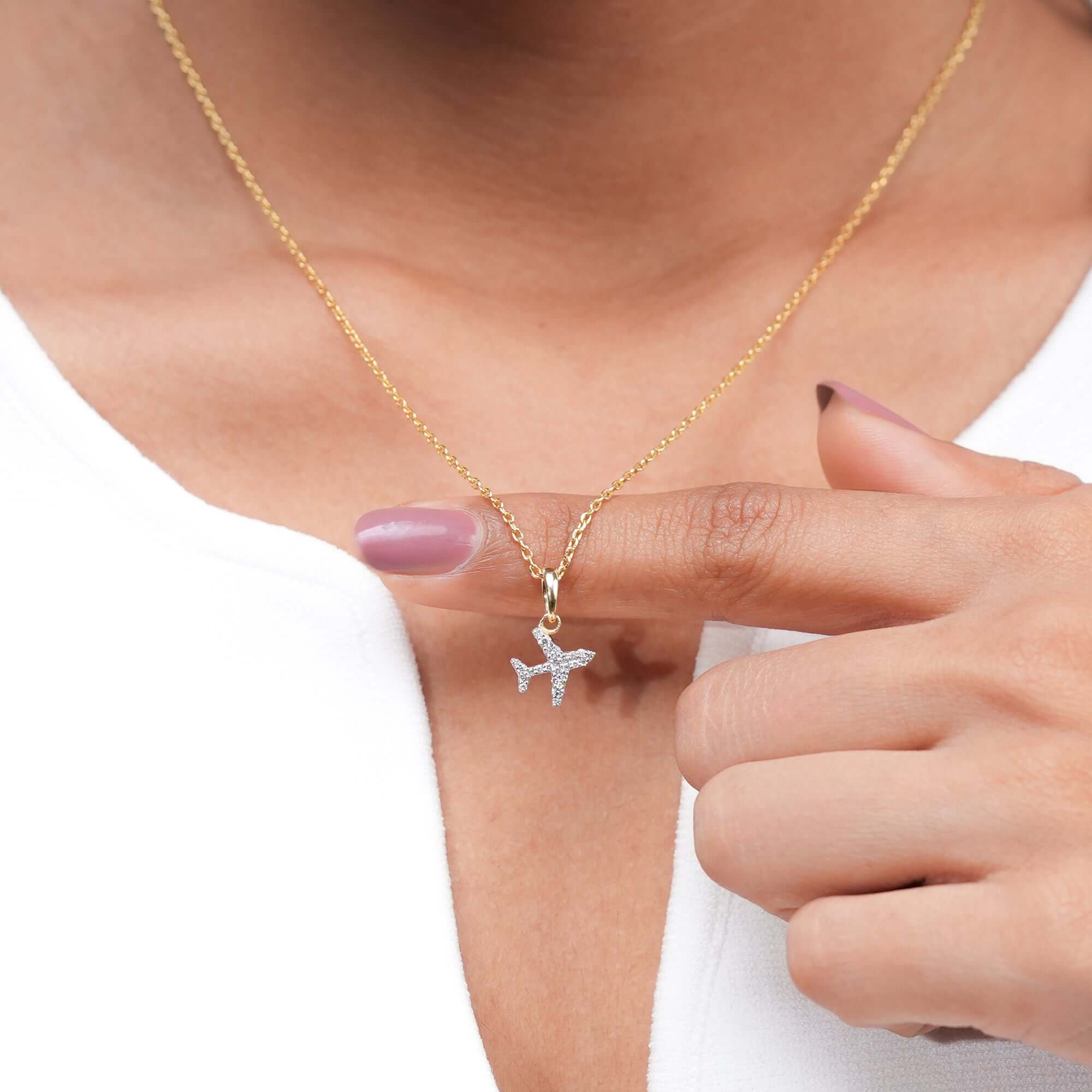 A sparkling airplane pendant hangs gracefully from a gold chain, representing freedom, adventure, and elegance in fine jewelry form.