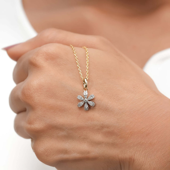 A chic gold necklace with a diamond-paved floral pendant, contemporary aesthetic.