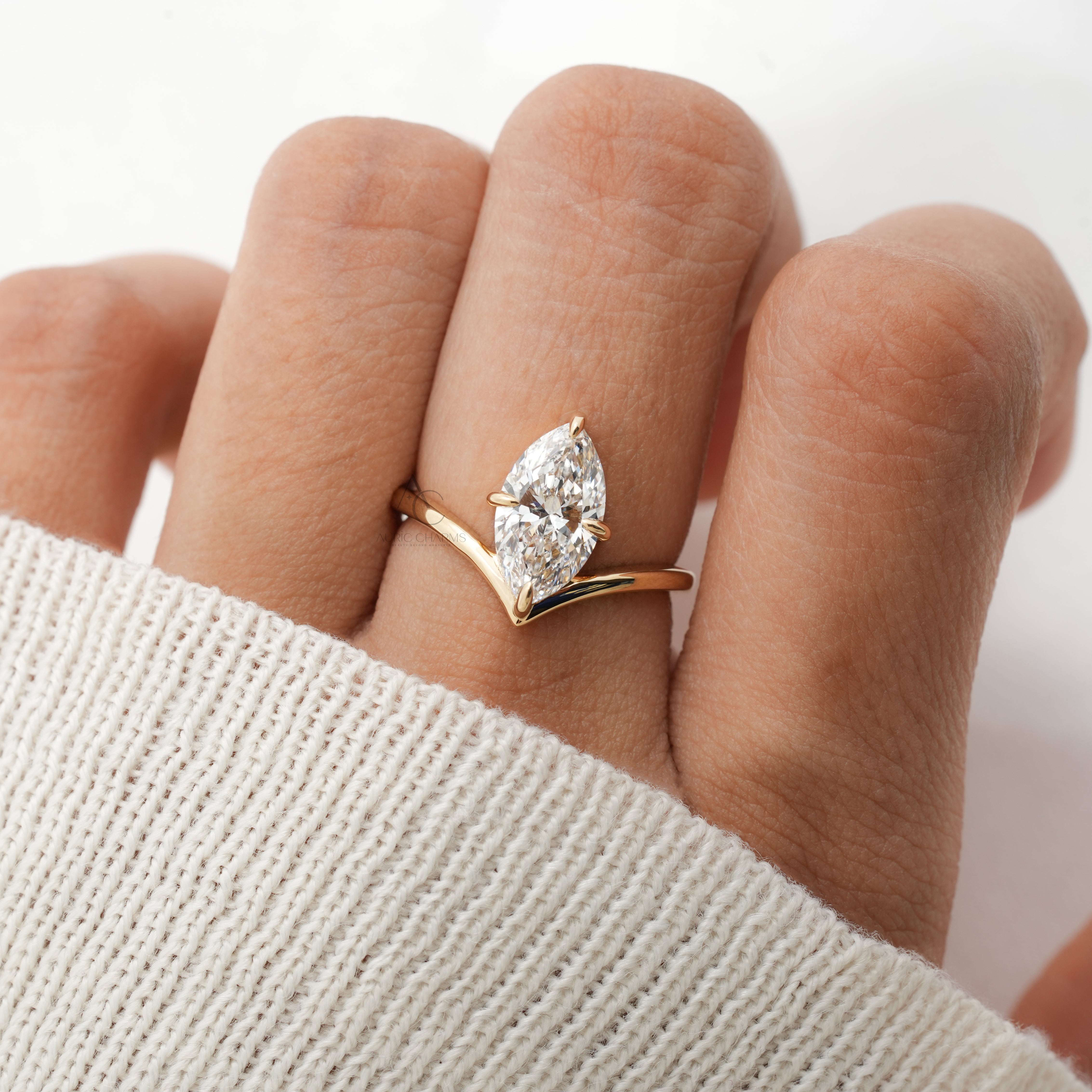 The Lyra Marquise Solitaire Lab Diamond Ring shines on a hand, showcasing its elegant gold arc and stunning marquise-cut diamond.