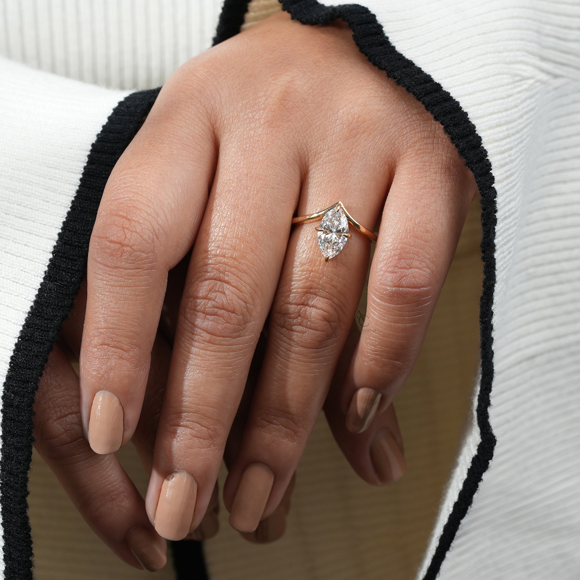 A hand adorned with the Lyra Marquise Solitaire Lab Grown Diamond Ring, radiating elegance and luxury in a golden setting.