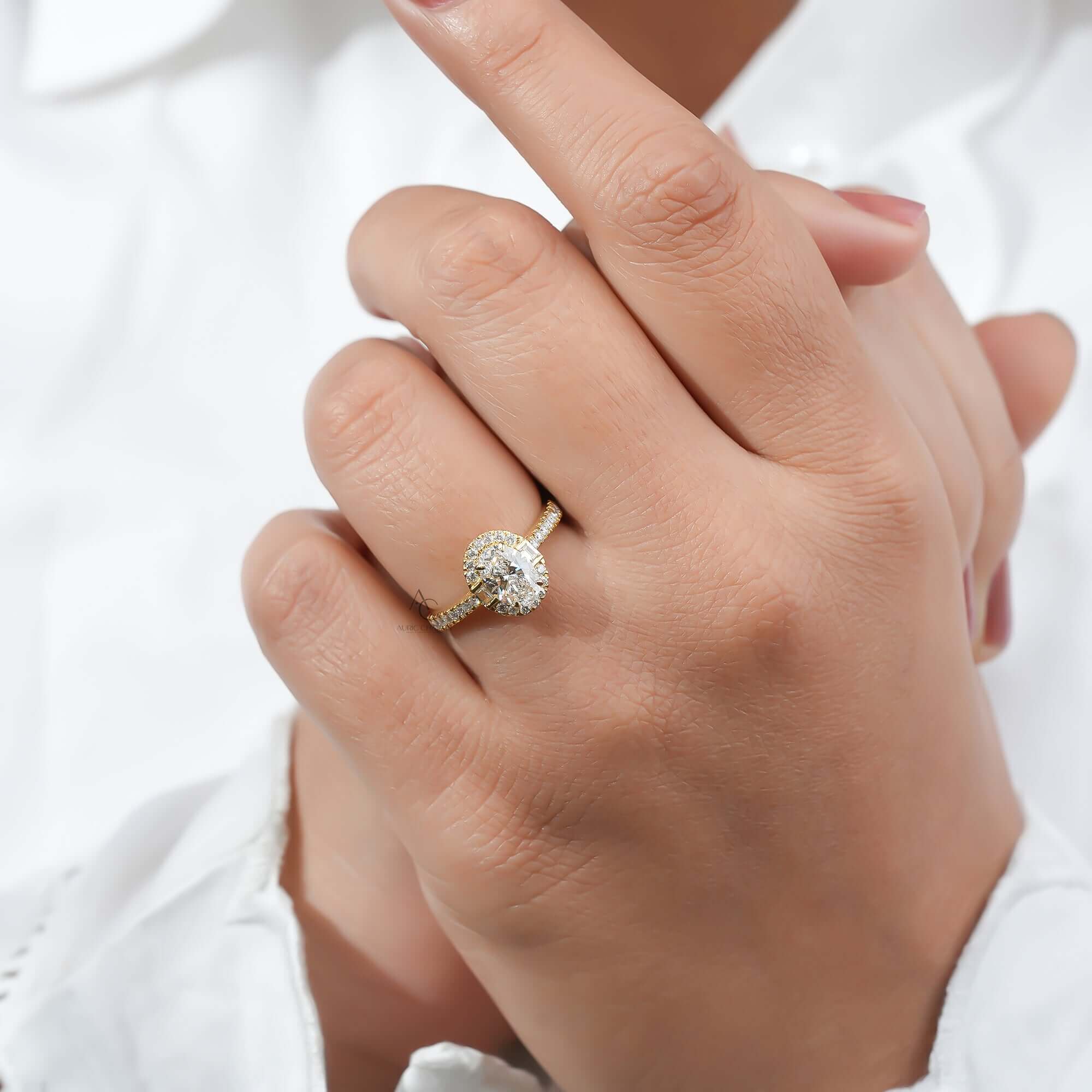 Oval diamond engagement ring on hand, halo and pave band.
