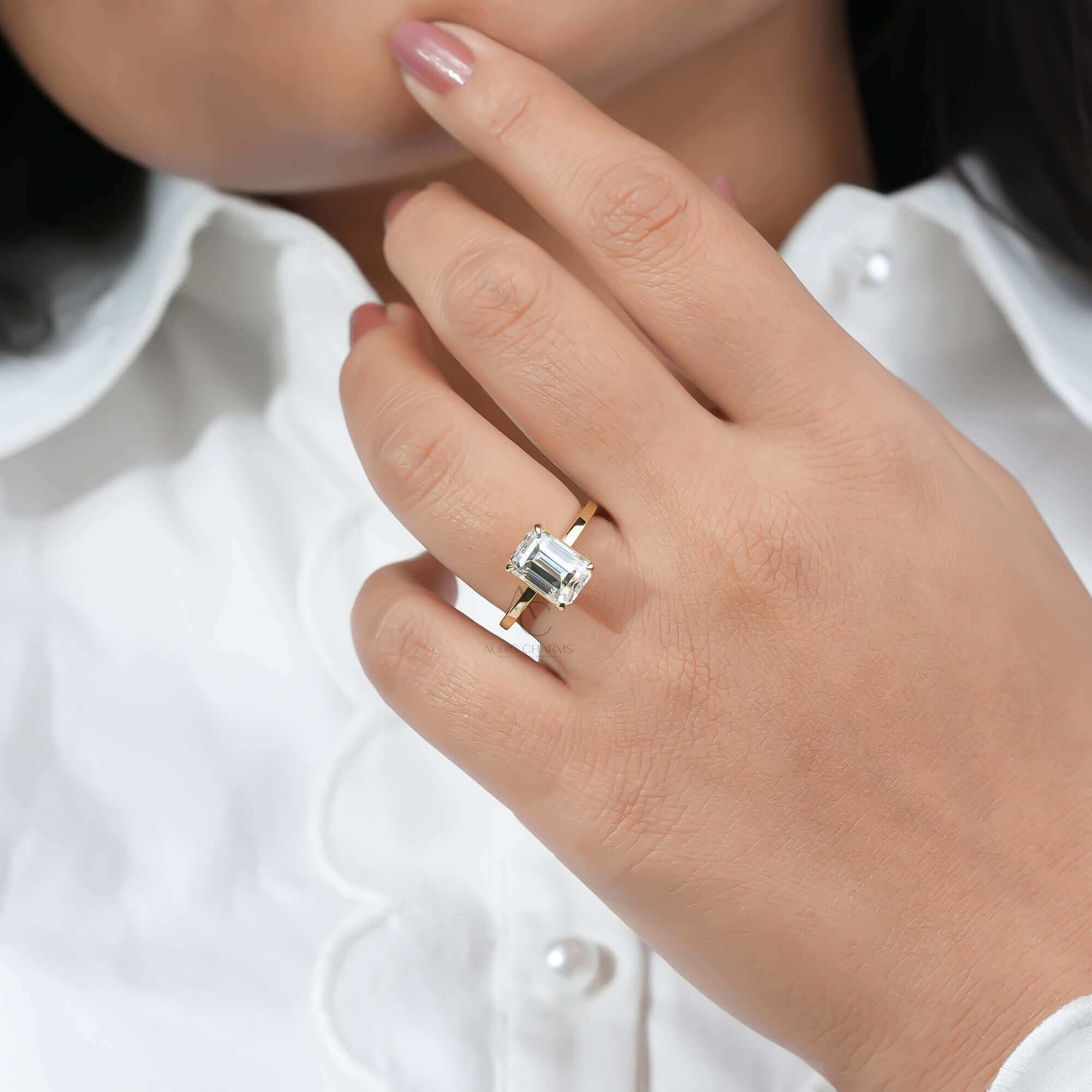 Emerald-cut diamond solitaire ring with sleek band.