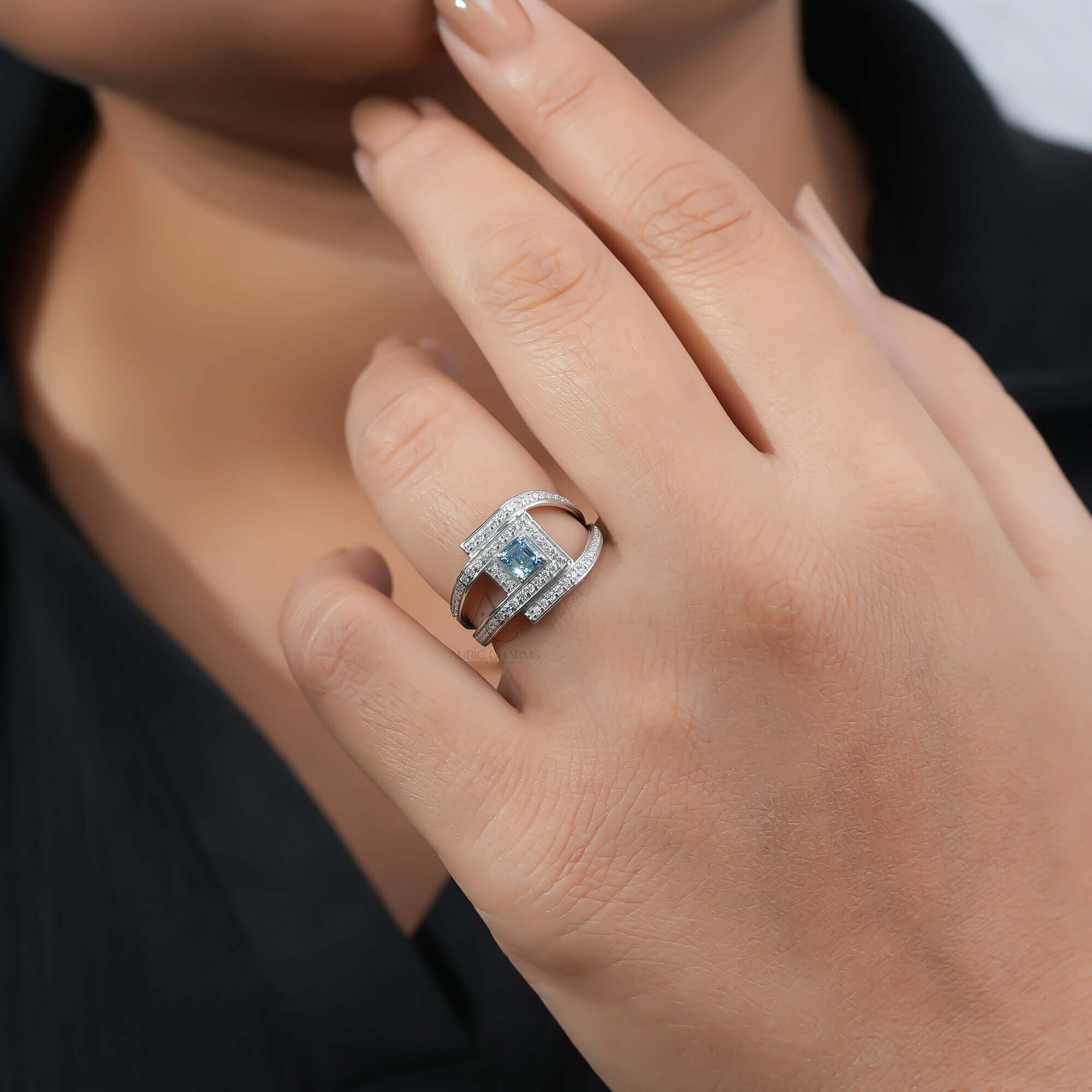 Square blue Diamond ring on finger, featuring diamond accents and modern design.