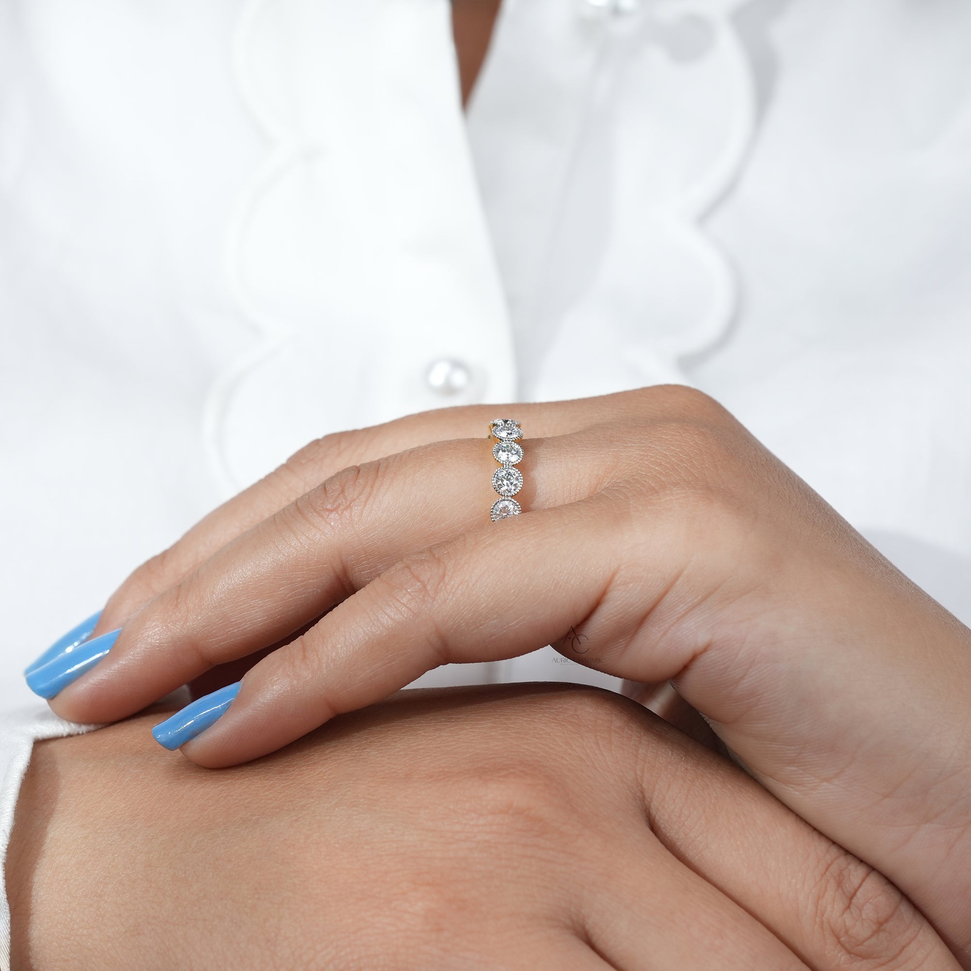 The Monroe Round Cut Bold Half Eternity Diamond Ring, featuring lab-grown diamonds, elegantly worn on a hand with blue nails.