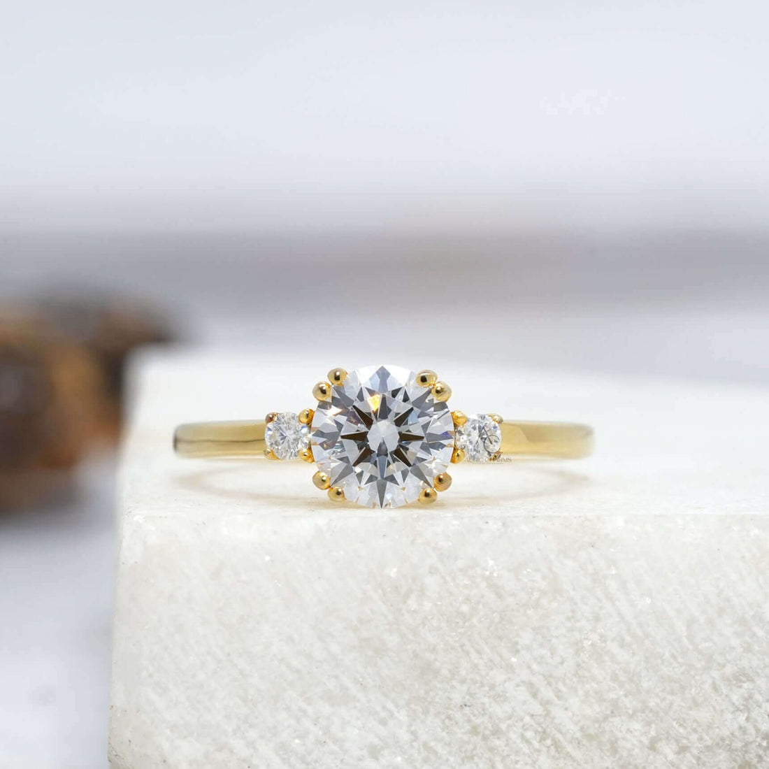 A stunning round-cut diamond engagement ring featuring a simple yet elegant band design, reflecting brilliance on a white surface.