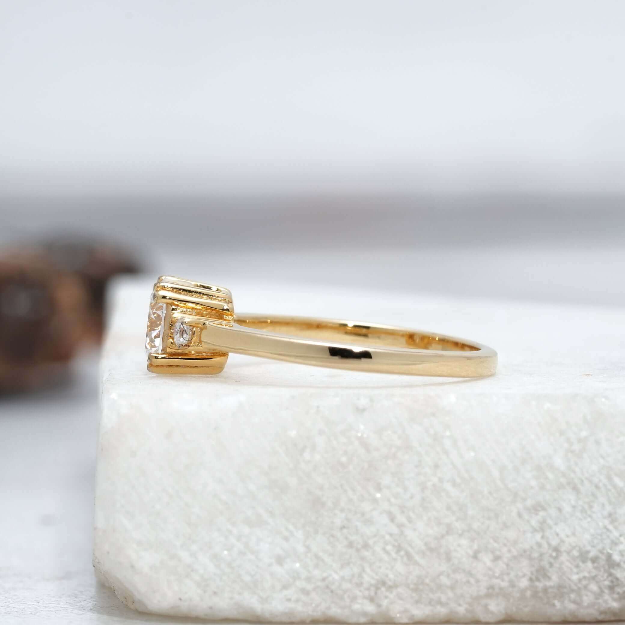 A radiant round-cut diamond ring with a classic three-stone setting, sparkling against a soft white background.