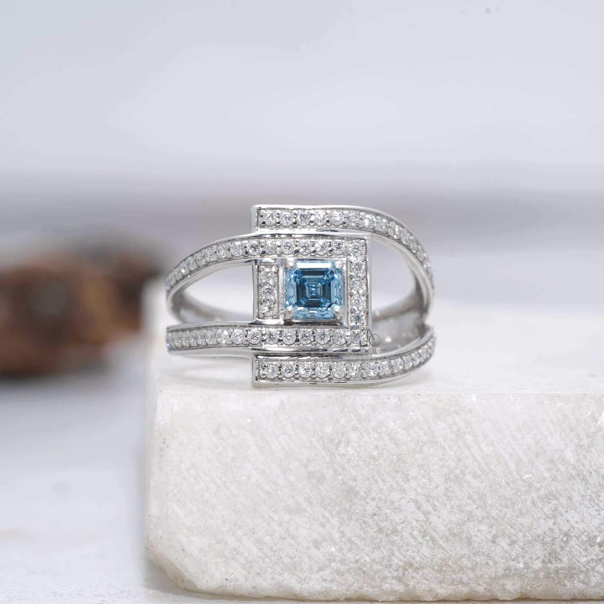 Square blue gemstone ring with diamond halo and double band