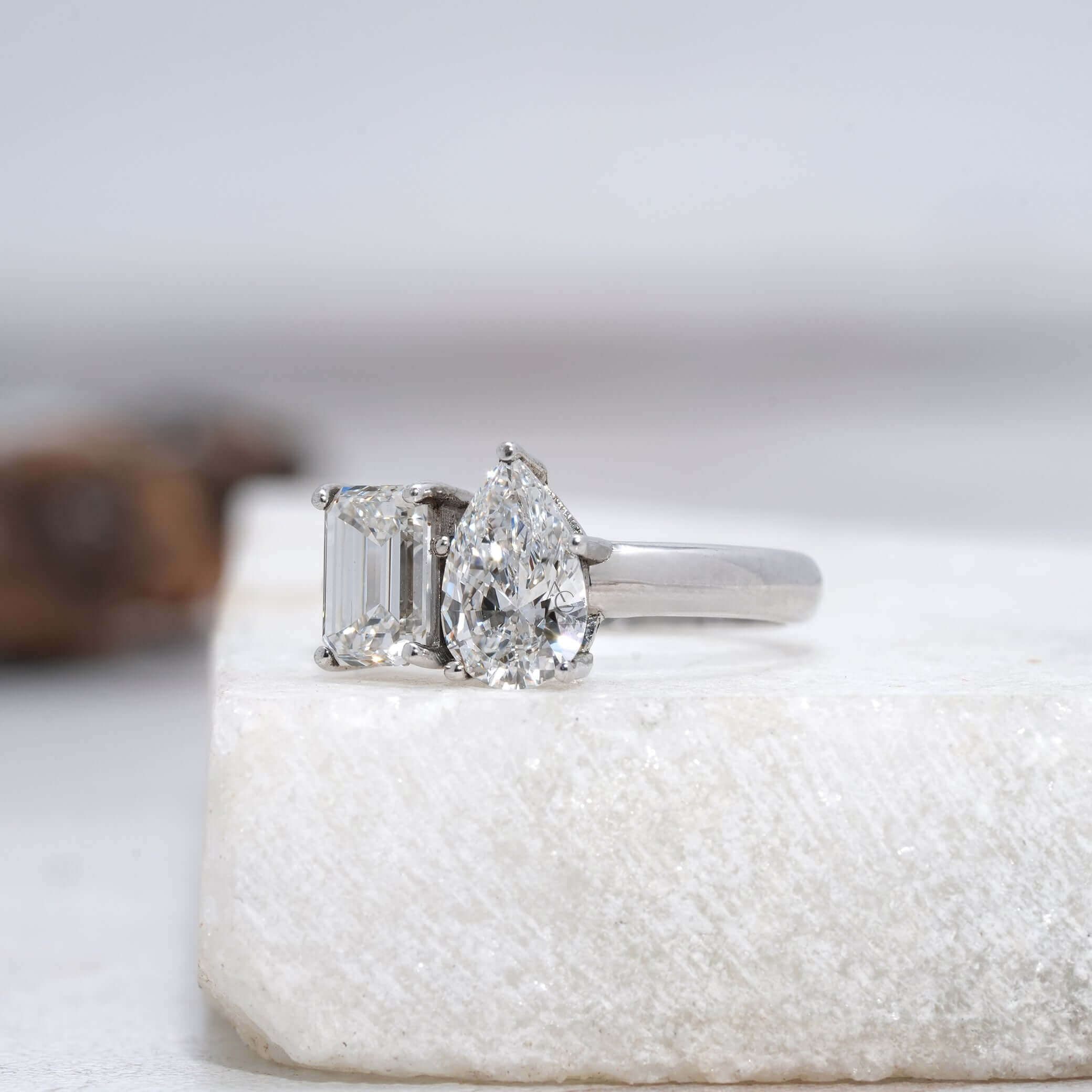 angled view of emerald and pear-cut Toi et Moi diamond ring showcasing craftsmanship.