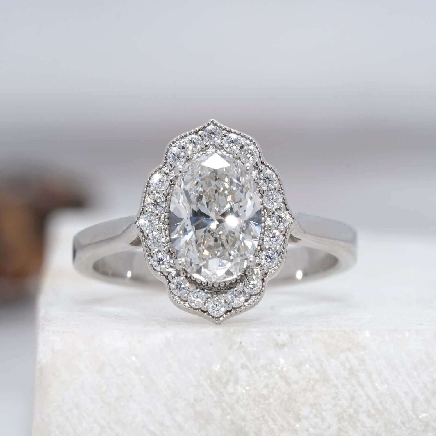 Oval-shaped lab-grown diamond ring with halo design and polished band.