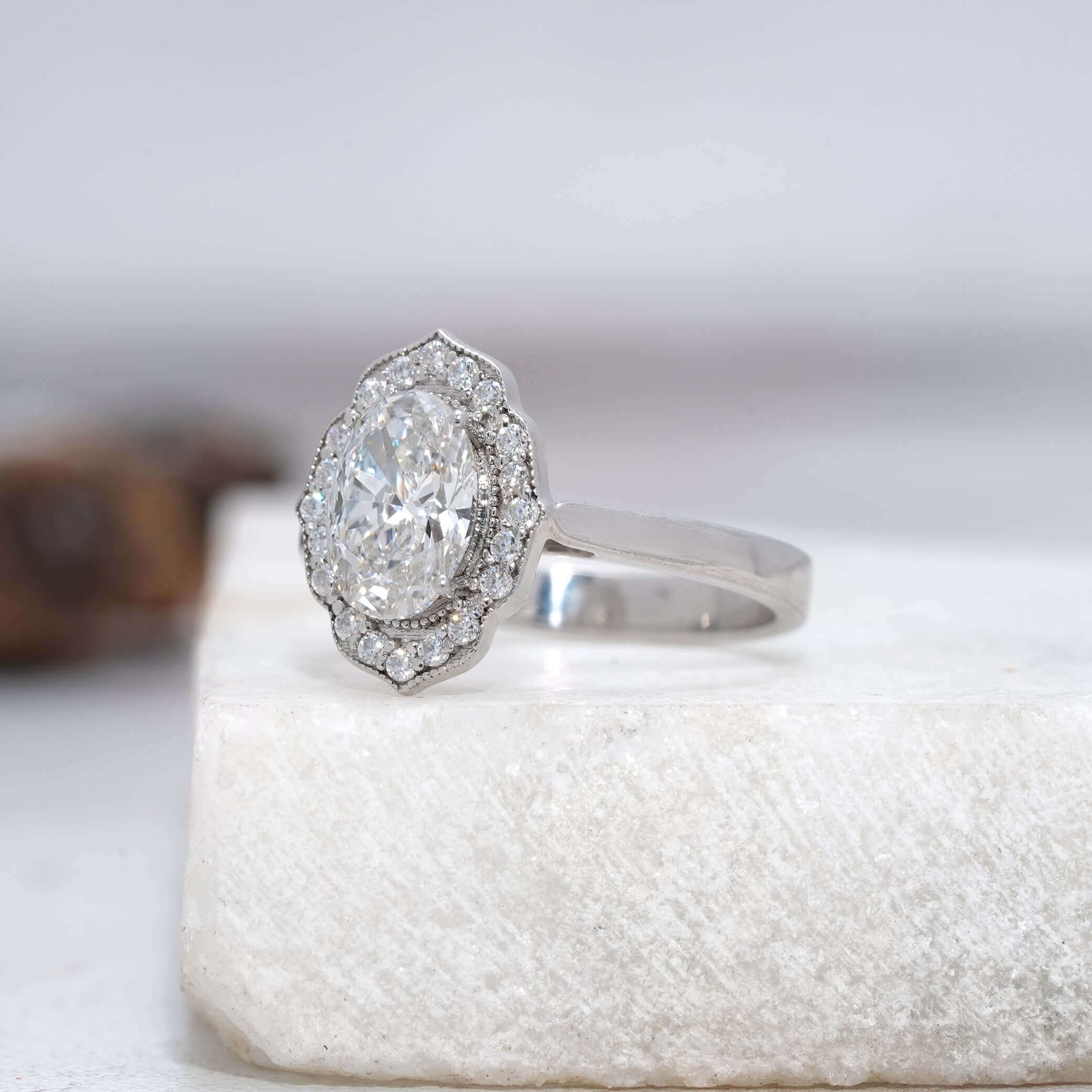 Side view of an oval diamond halo ring showcasing intricate craftsmanship.