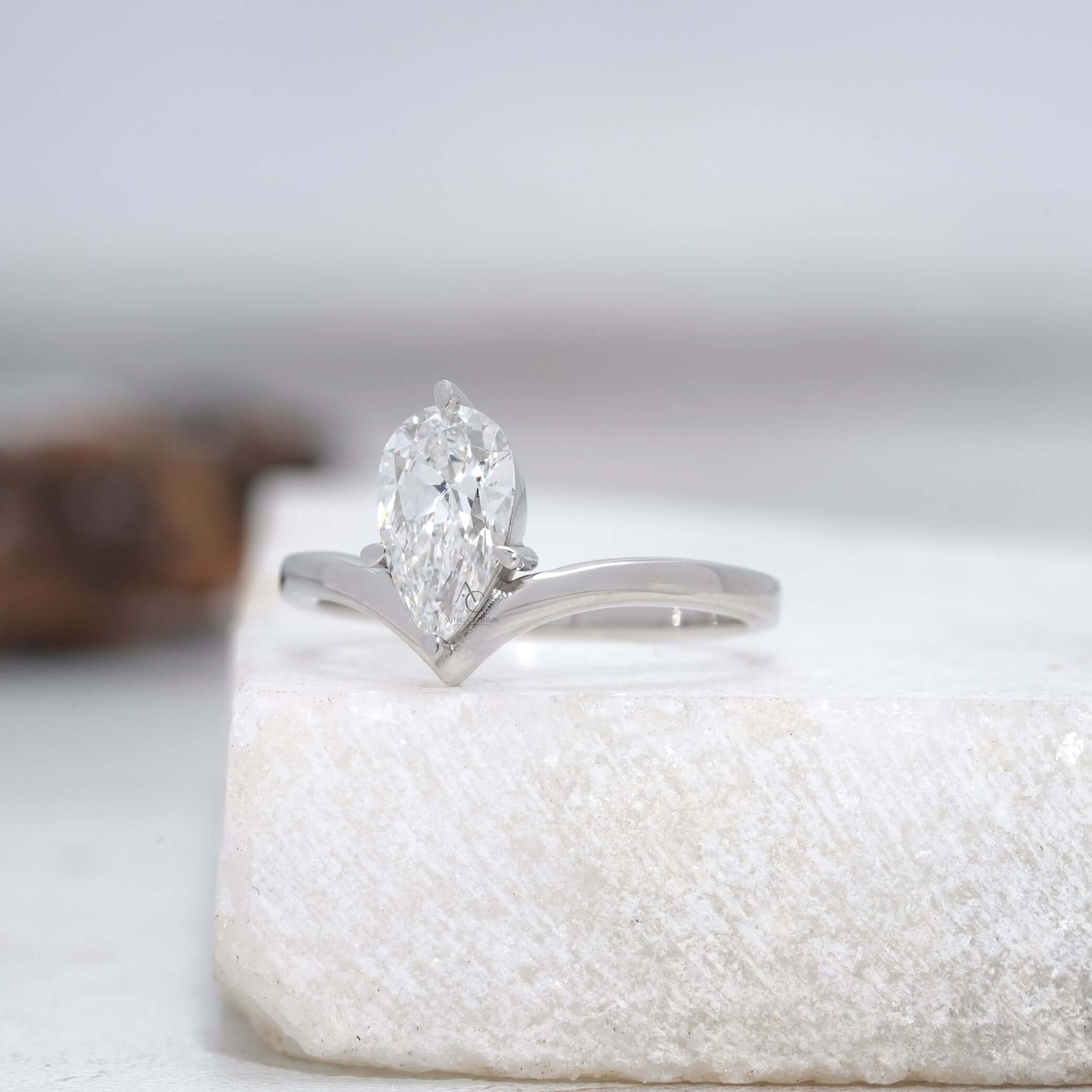 Detailed view of a pear-cut diamond engagement ring showcasing the intricate prong setting and polished band.