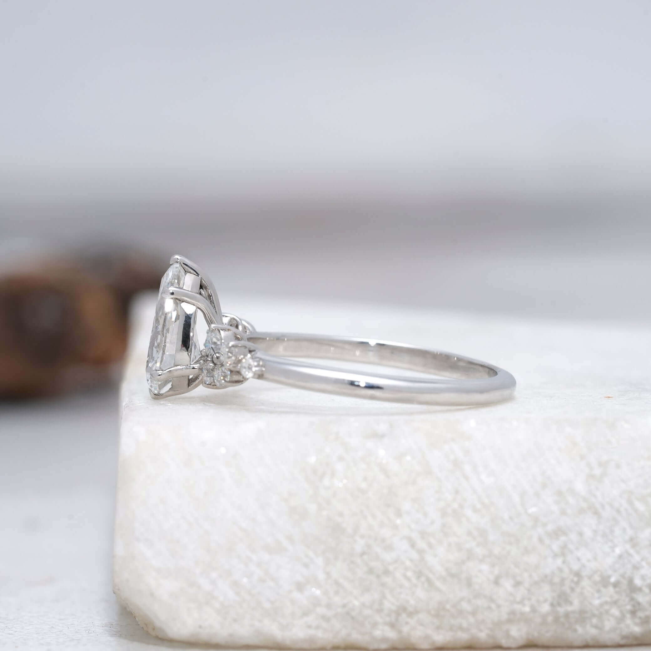 side view of a pear-cut diamond ring showcasing the unique prong setting and band design.