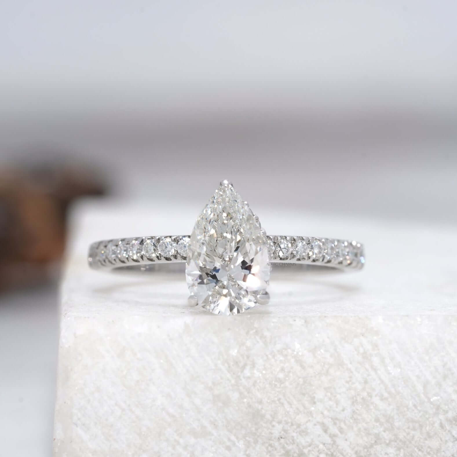 Pear-cut diamond ring with a shimmering halo and delicate diamond band.