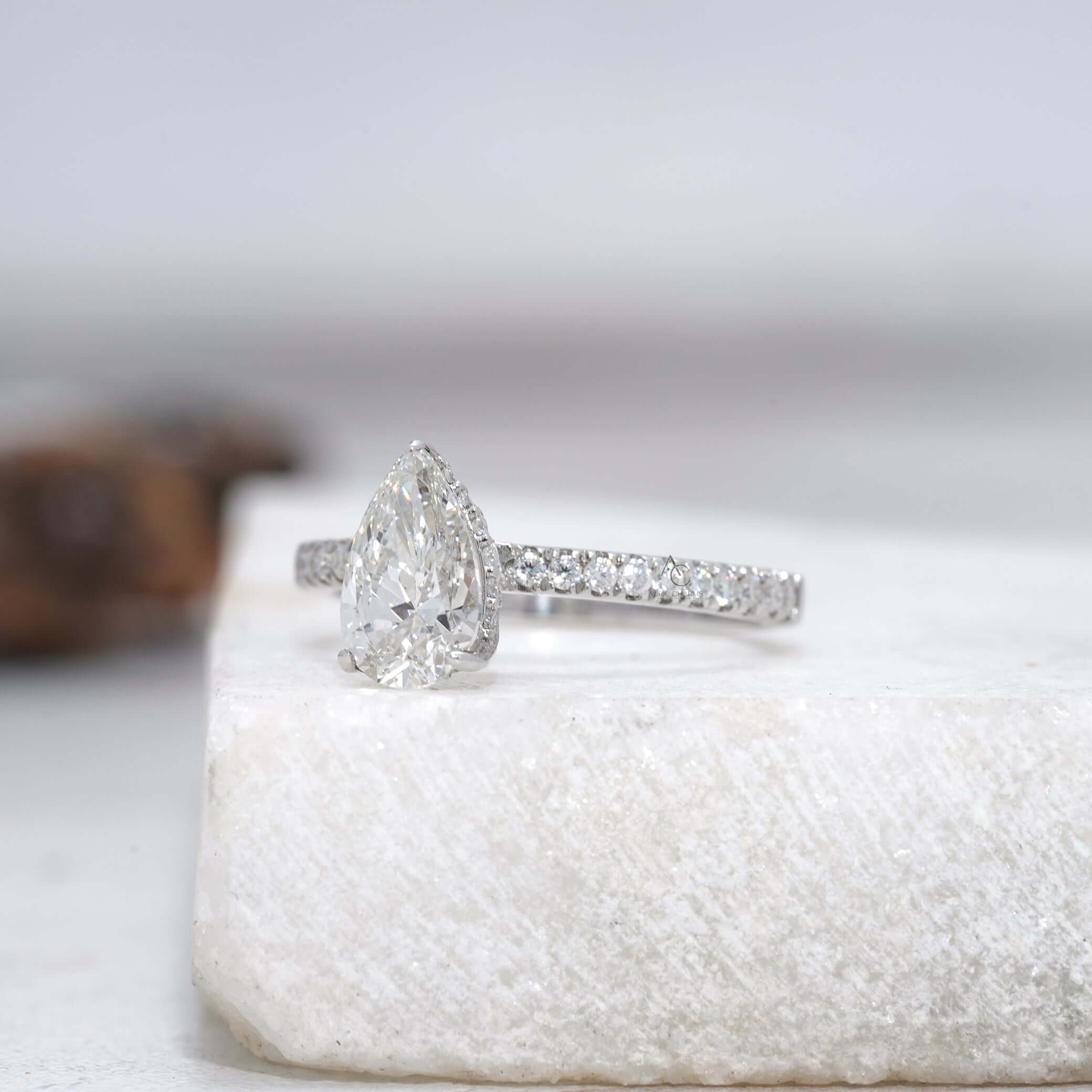 Angled view of a pear-cut diamond ring showcasing intricate halo design.