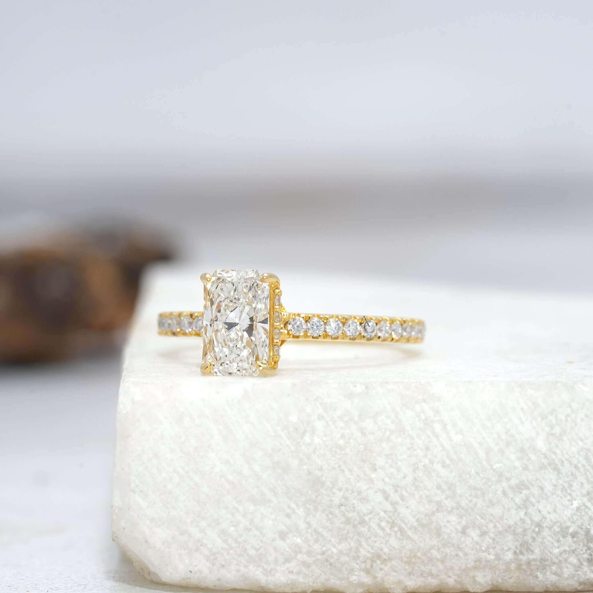 Side view of radiant-cut diamond ring with intricate pavé detailing for timeless elegance.