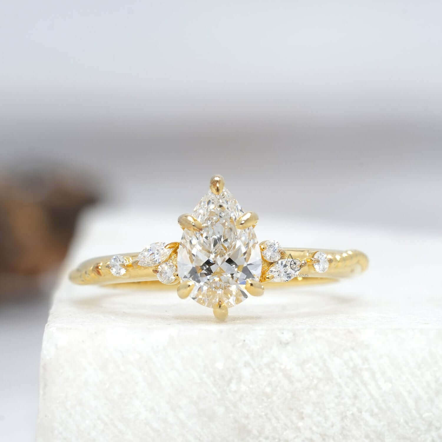 Elegant floral diamond engagement ring with pear-cut center stone and intricate details.