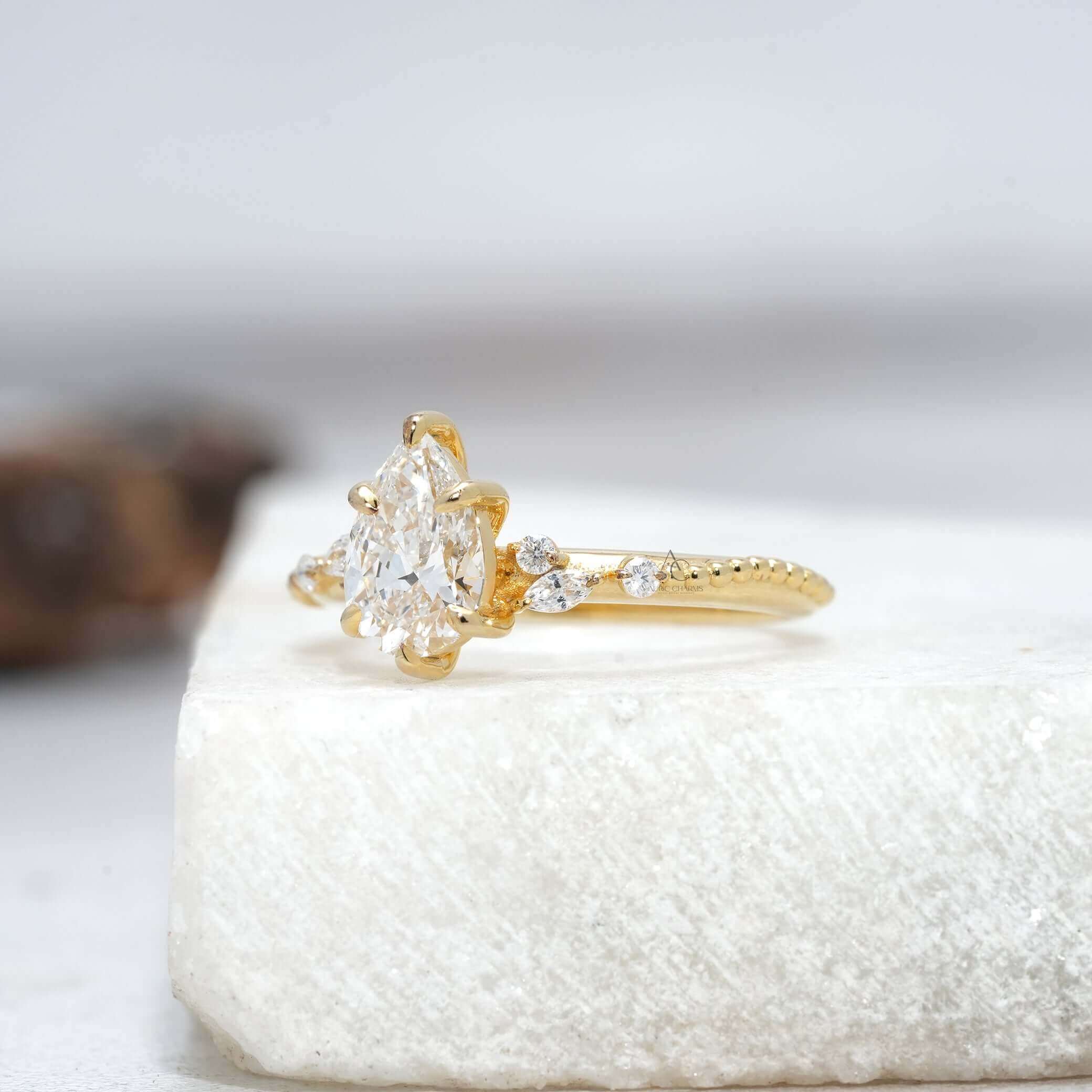 Side view of pear-shaped diamond ring showcasing delicate craftsmanship and unique band design.