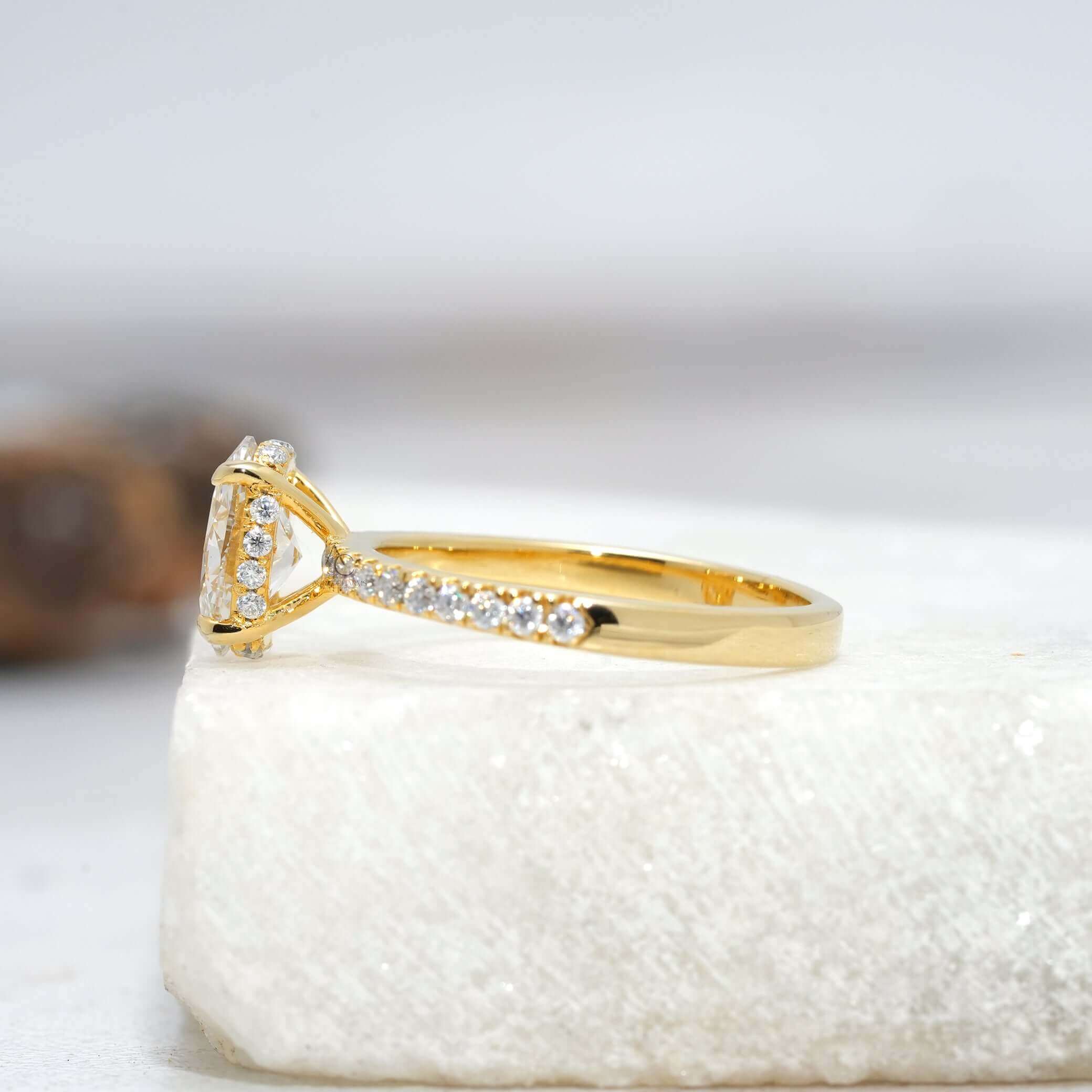 Profile of oval diamond solitaire ring with sparkling pave band, crafted for luxury.