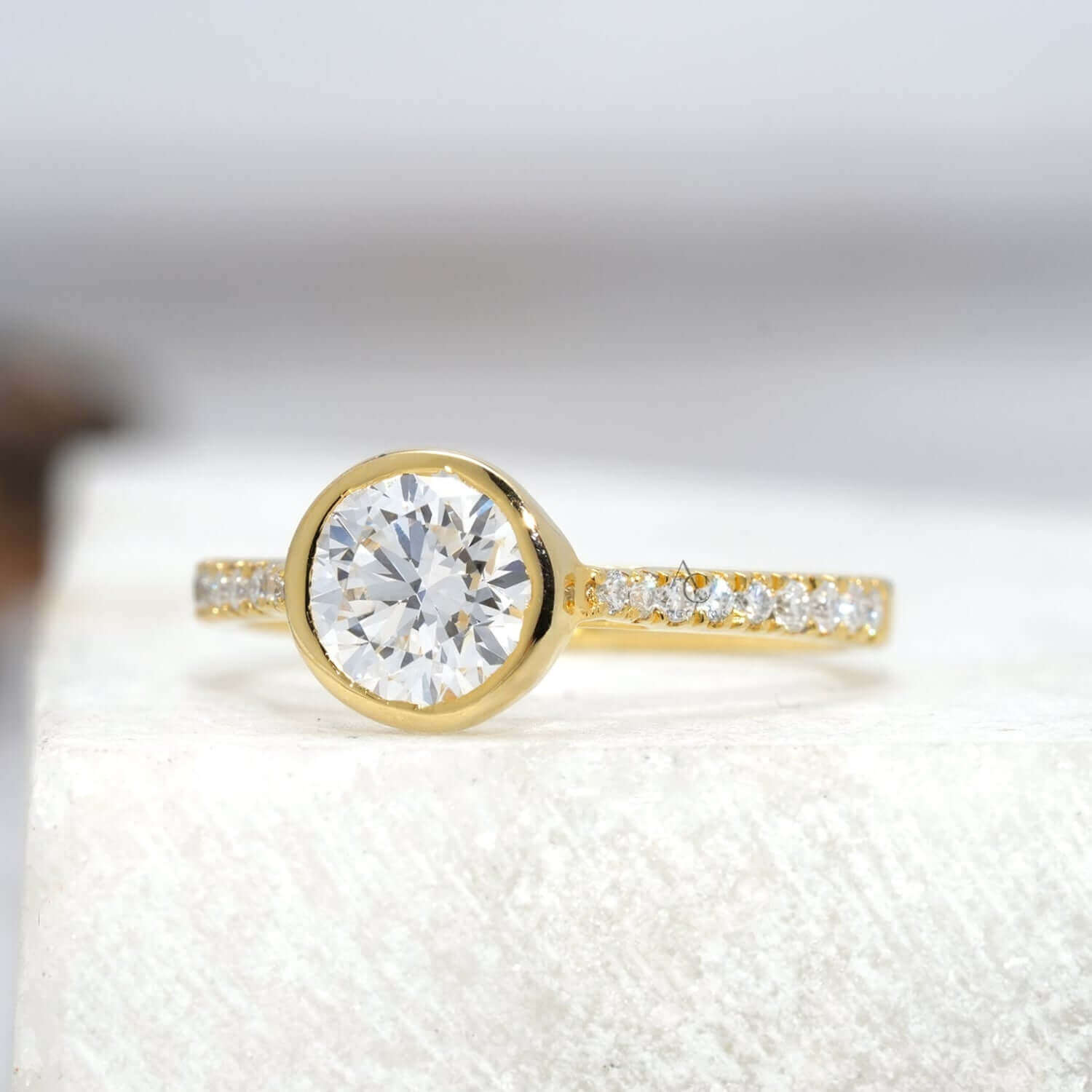 Side view of bezel-set diamond ring with pave band.