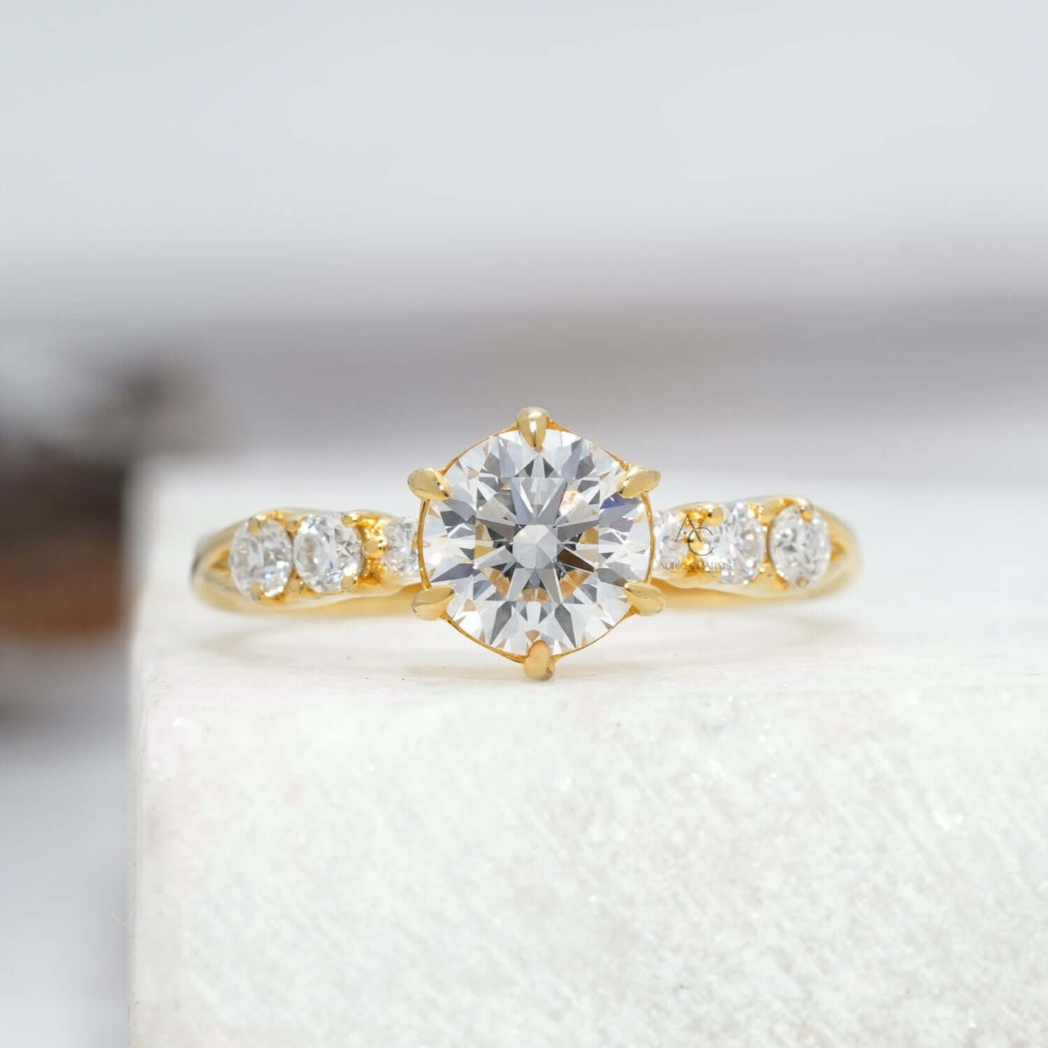 Round brilliant lab-grown diamond engagement ring with six-prong setting and pave accents.