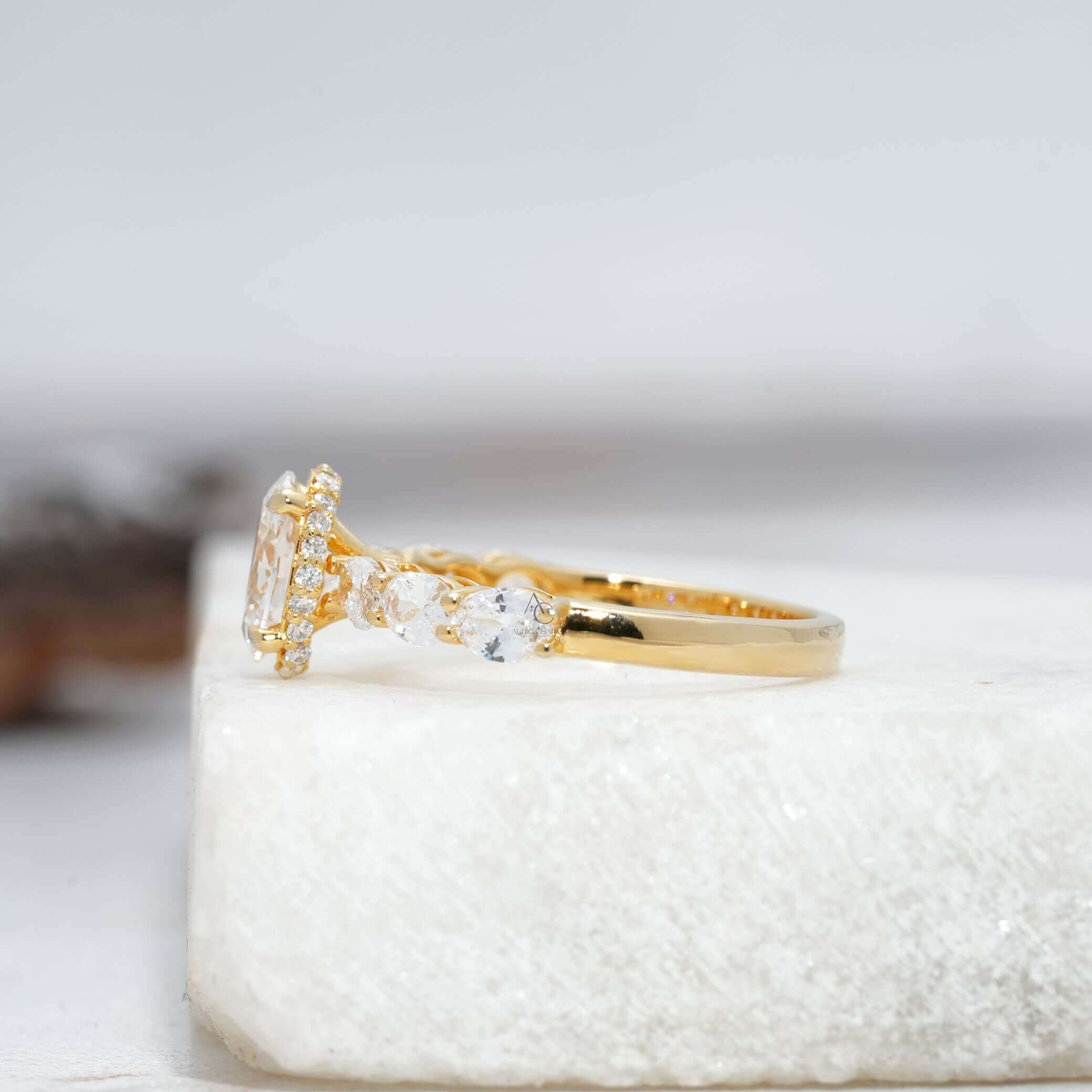 Angled oval diamond ring showing prong setting and side stones.