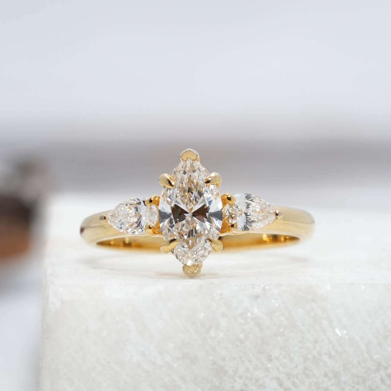 Front-facing view of marquise diamond ring with pear-cut accents, minimalistic elegance.