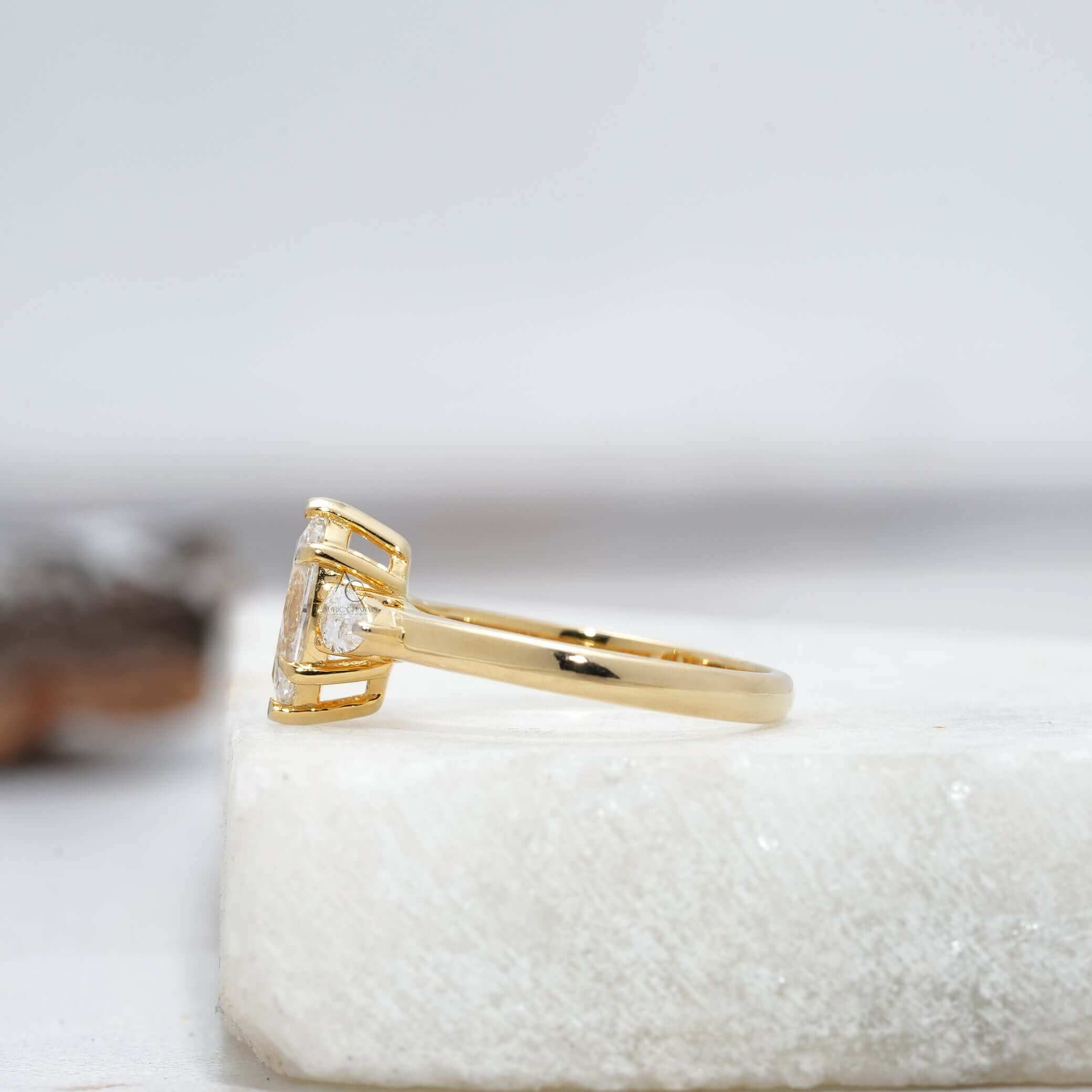 Side view of marquise diamond ring showing pear-cut accents and sleek metal band design.