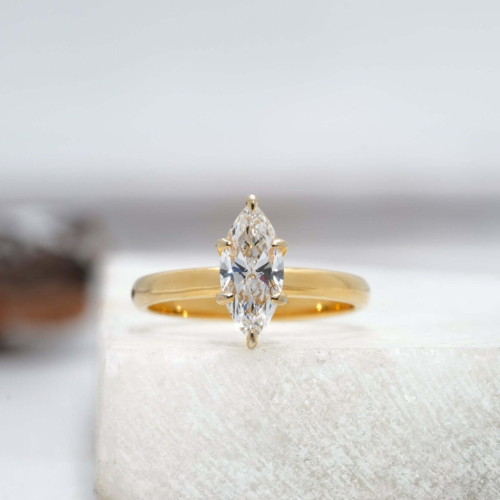 Front-facing view of a minimalist solitaire ring featuring a marquise-cut diamond set in a sleek, polished band with a timeless design.