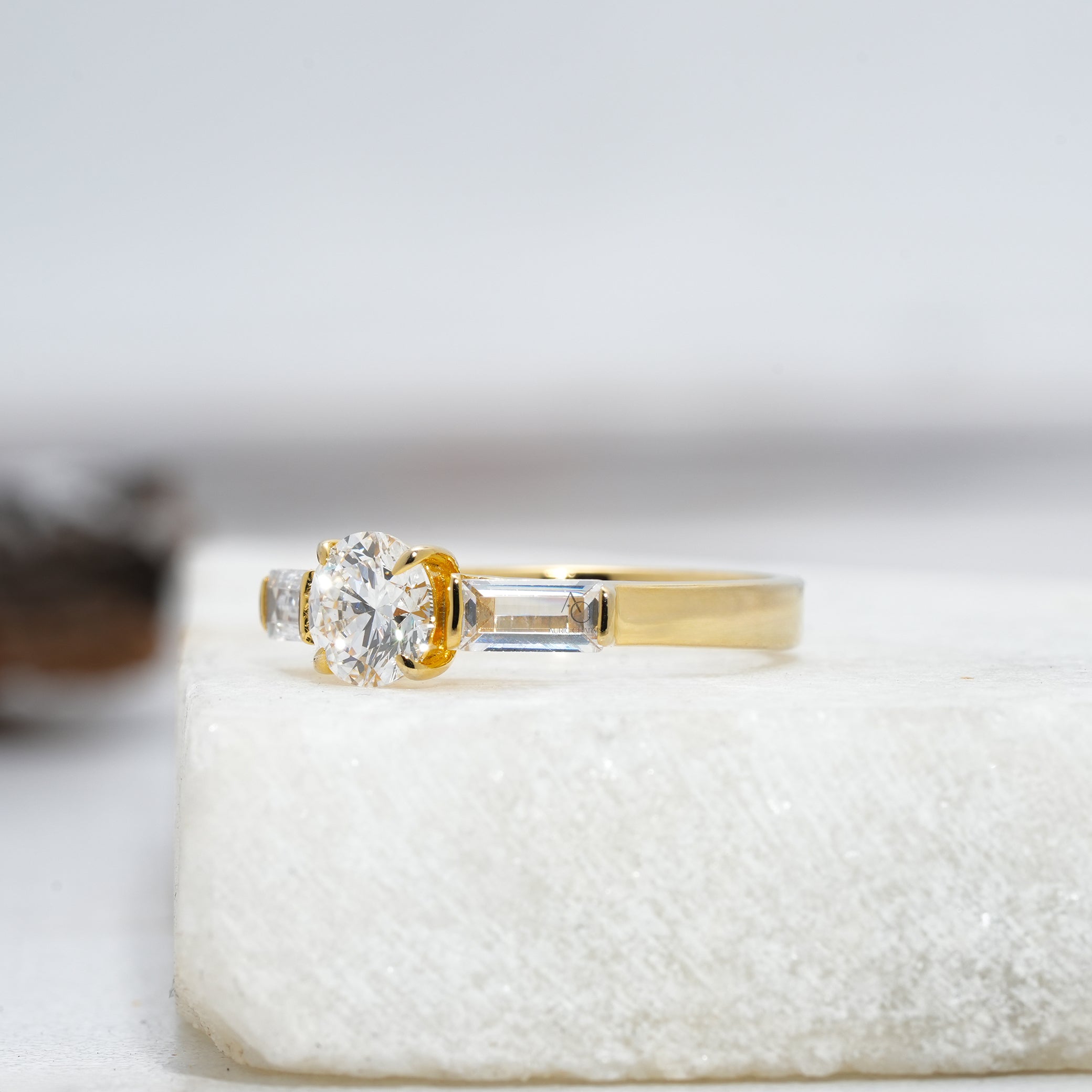 Side view of a round diamond engagement ring showcasing brilliant baguette-cut accents and a sleek platinum band