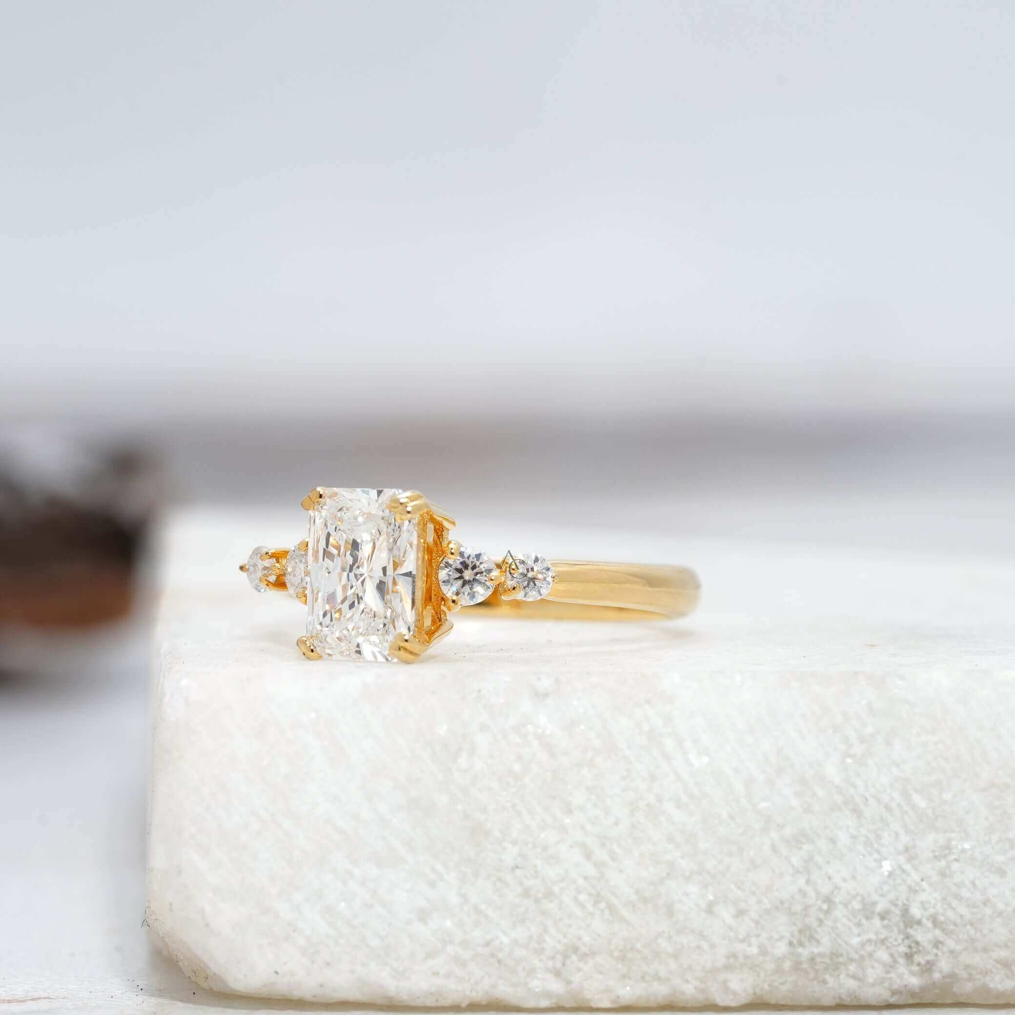 Elegant radiant-cut diamond ring with sparkling side stones, set in white gold.