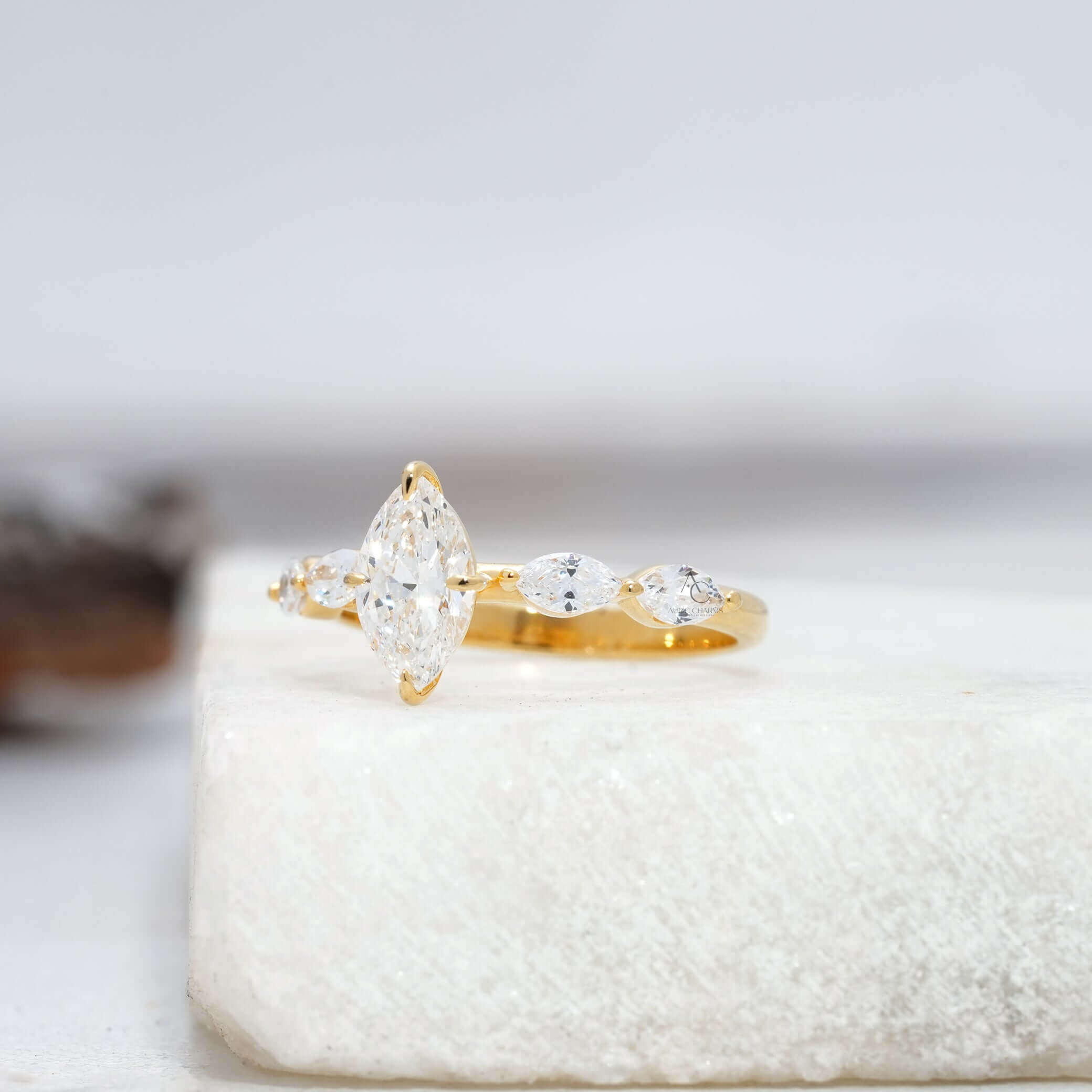 Side view of marquise-cut diamond ring with accent stones.
